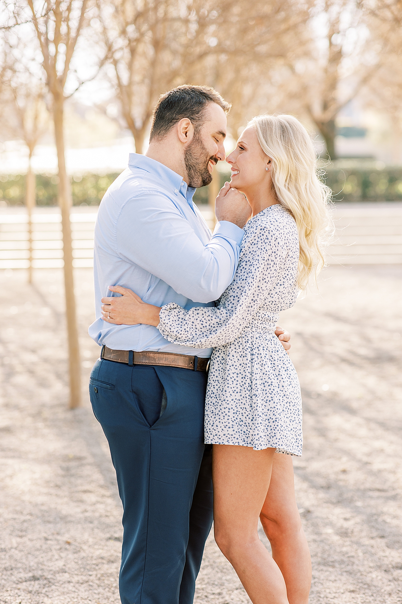 groom holds bride's chin lifting her face during Kimball Art Museum engagement photos