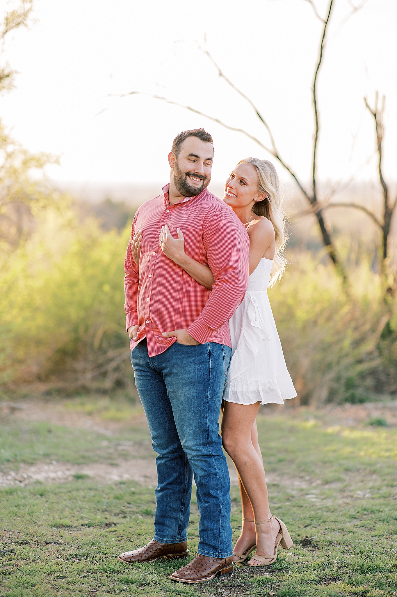 bride and groom pose in field in Dallas TX