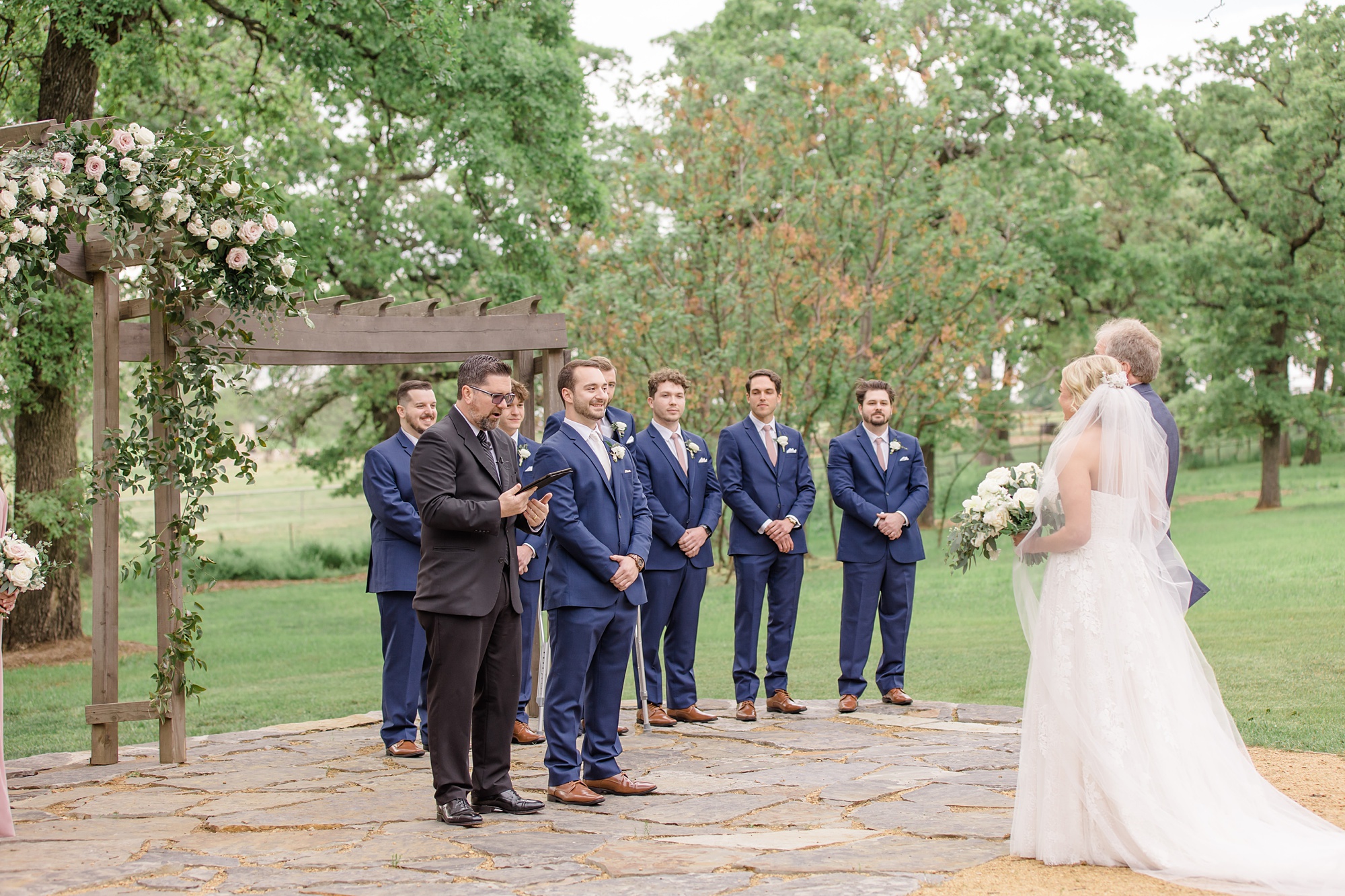 groom watches bride walk down aisle during ceremony at Oak + Ivy