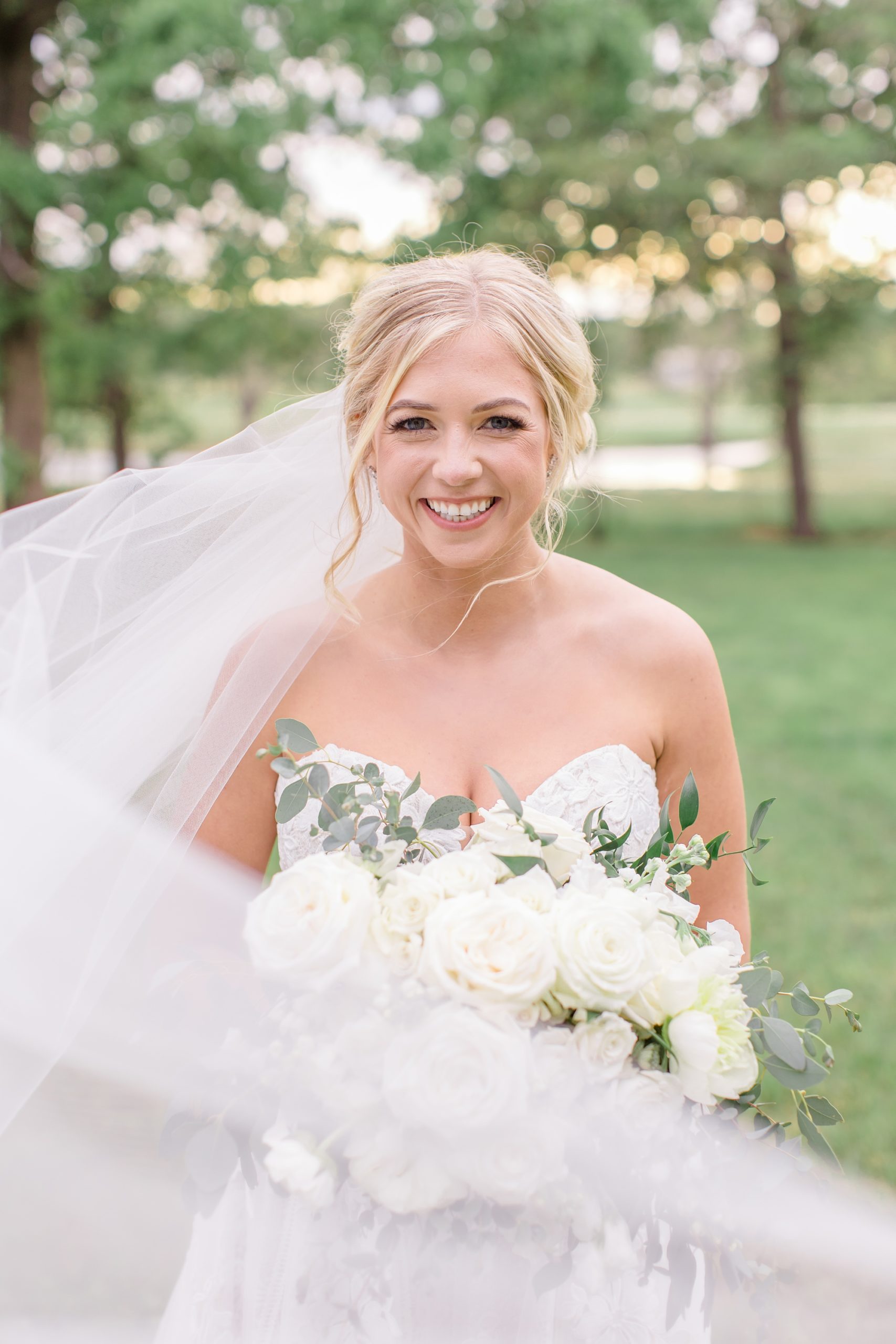 bride smiles at photographer during Oak + Ivy bridal portraits