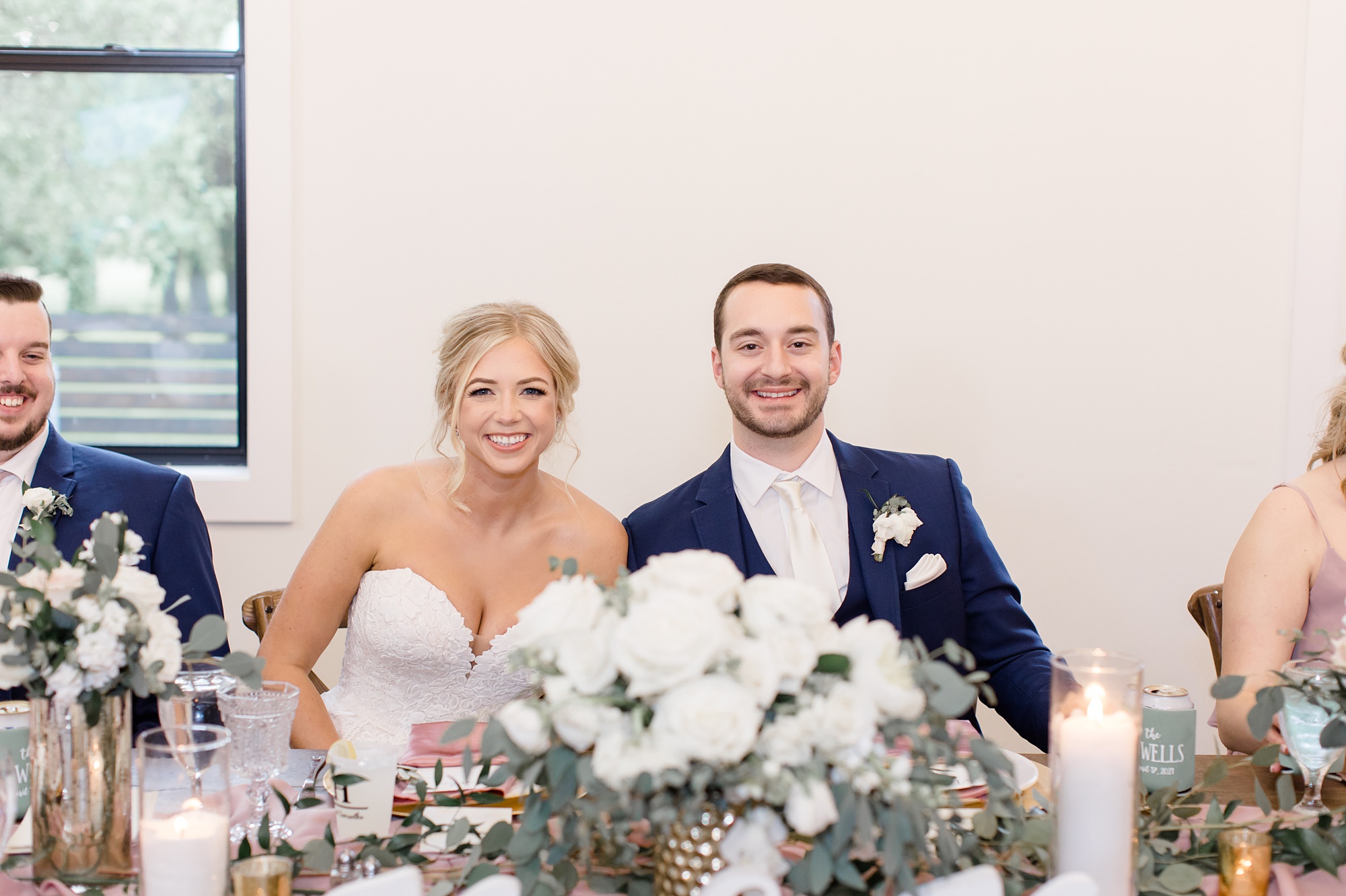 bride and groom sit at sweetheart table 