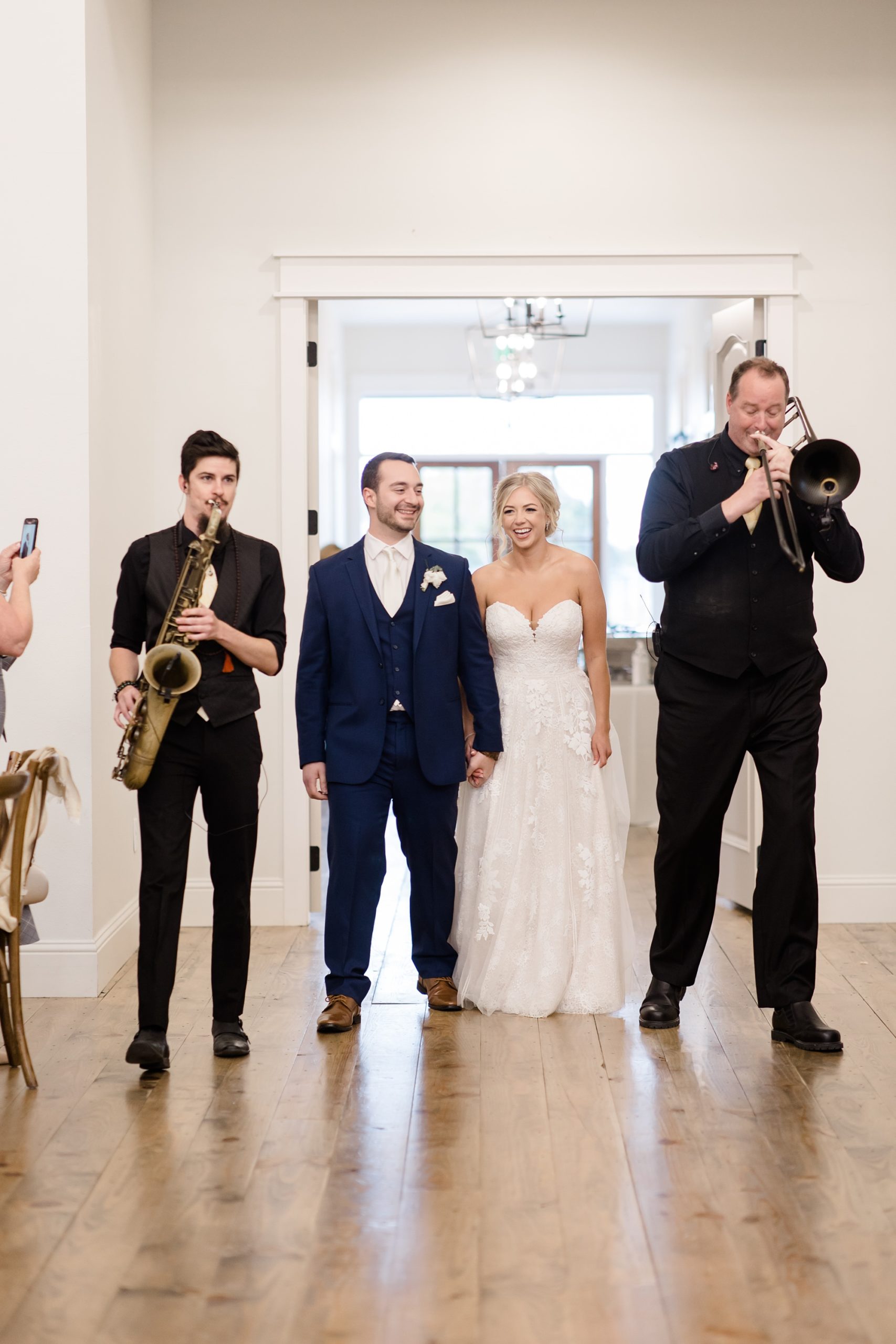 bride and groom walk into reception with band members playing 