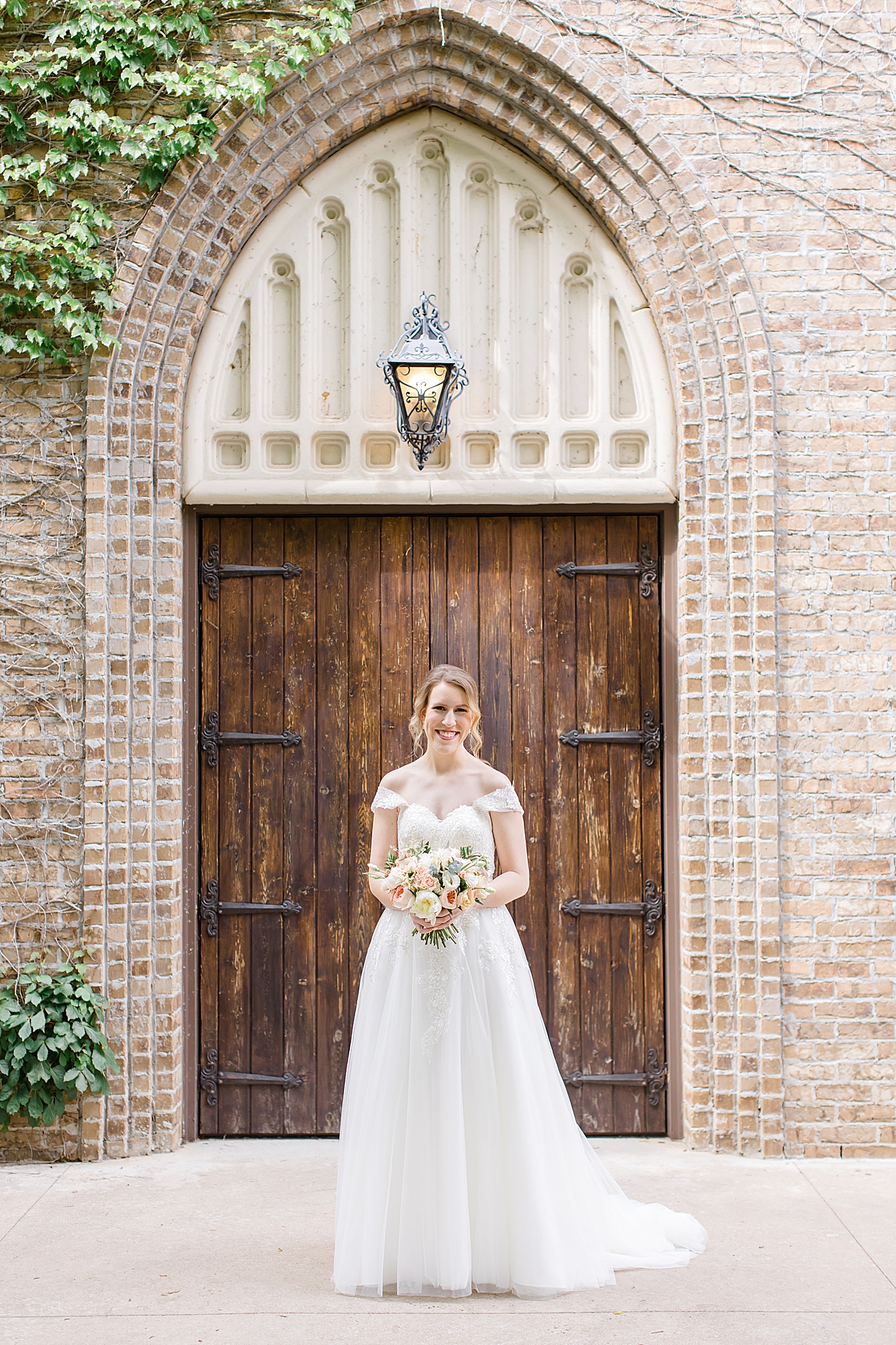 bride poses outside wooden door during Aristide Mansfield bridal portraits