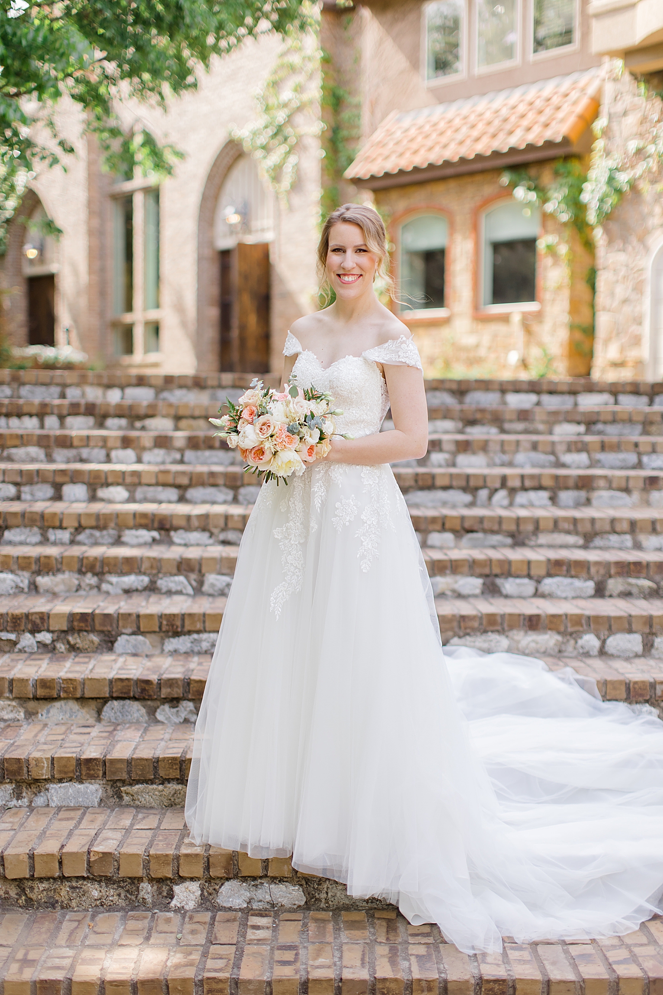 bride poses on steps of Texas wedding venue 