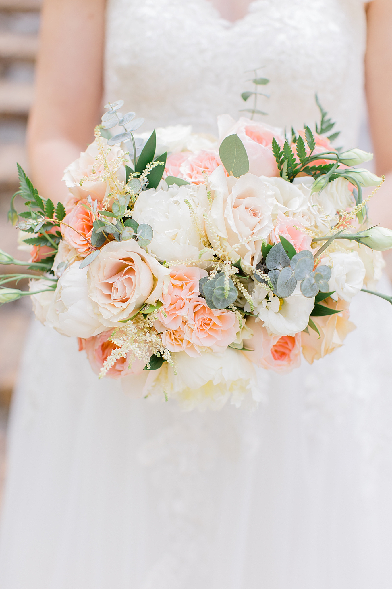bride holds bouquet of pastel flowers 
