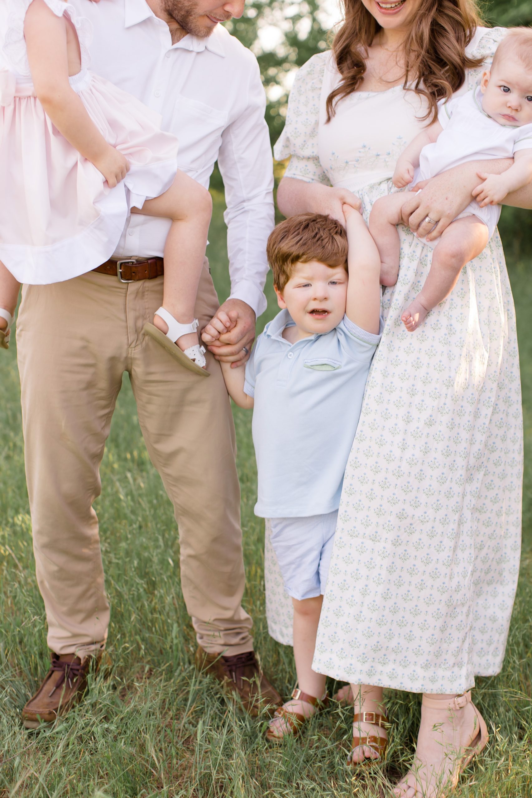 toddler holds mom and dads hand during family photos in Murrell Park