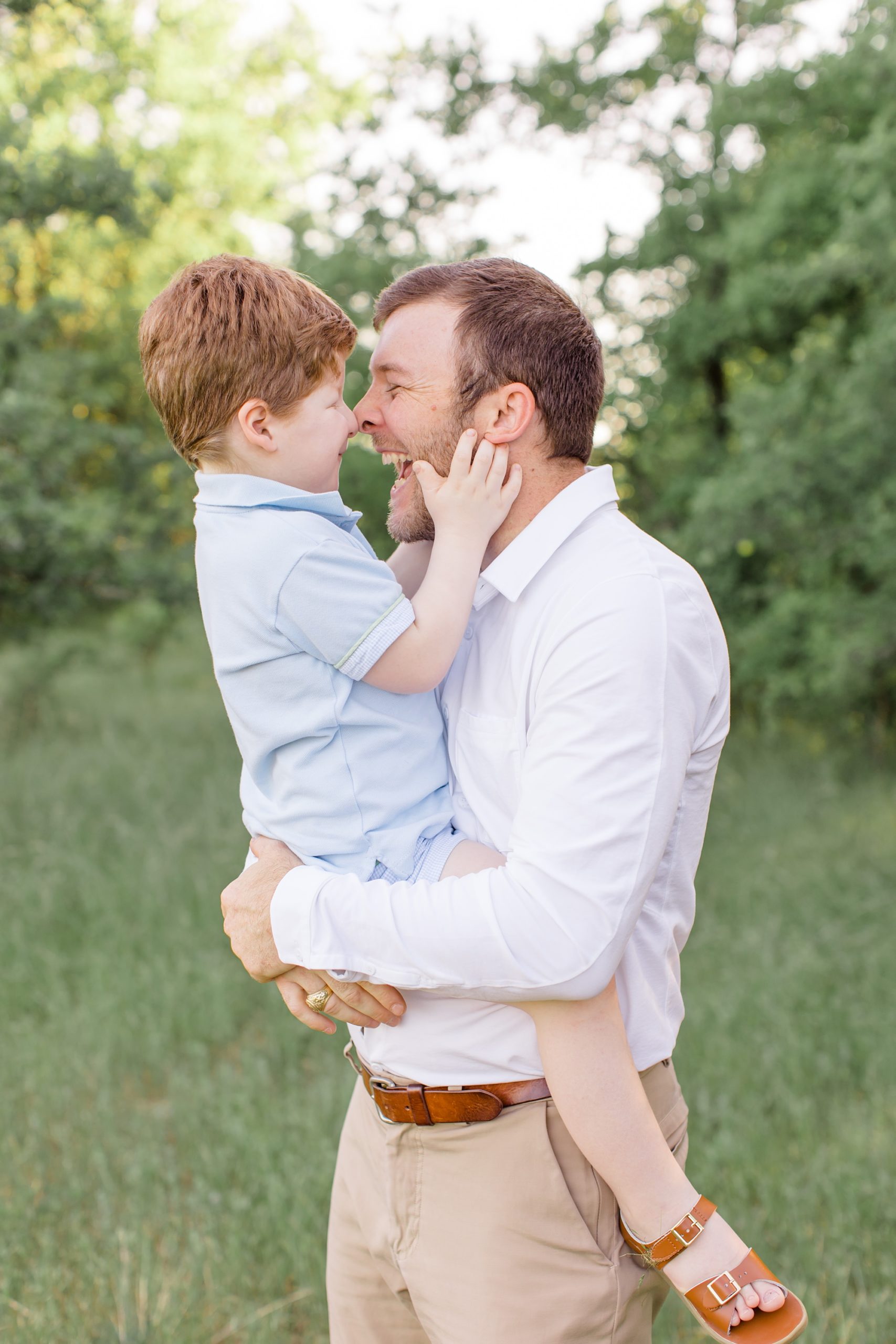 dad laughs with son during family portraits in Texas 