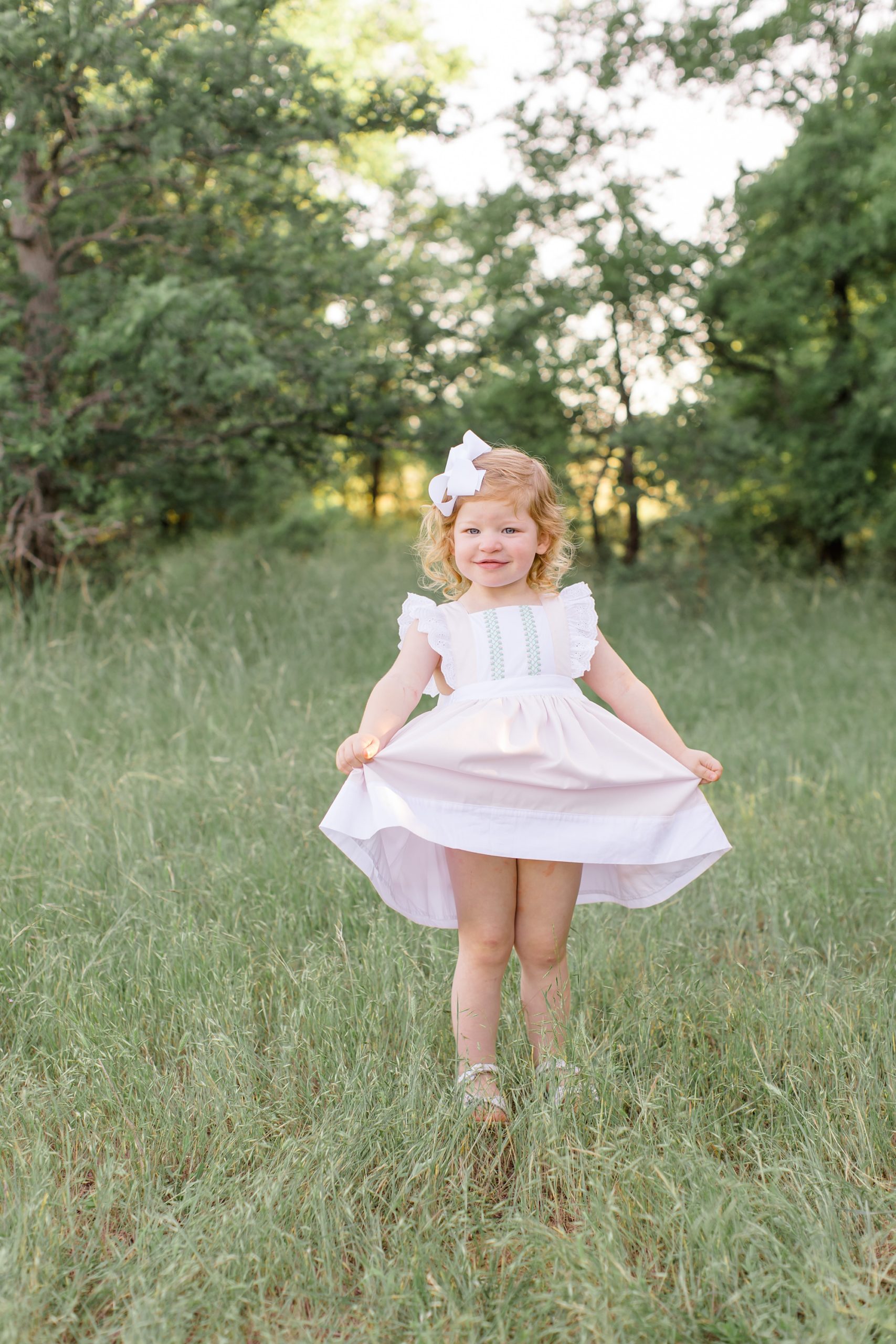 toddler shows off pink dress during spring portraits in Murrell Park