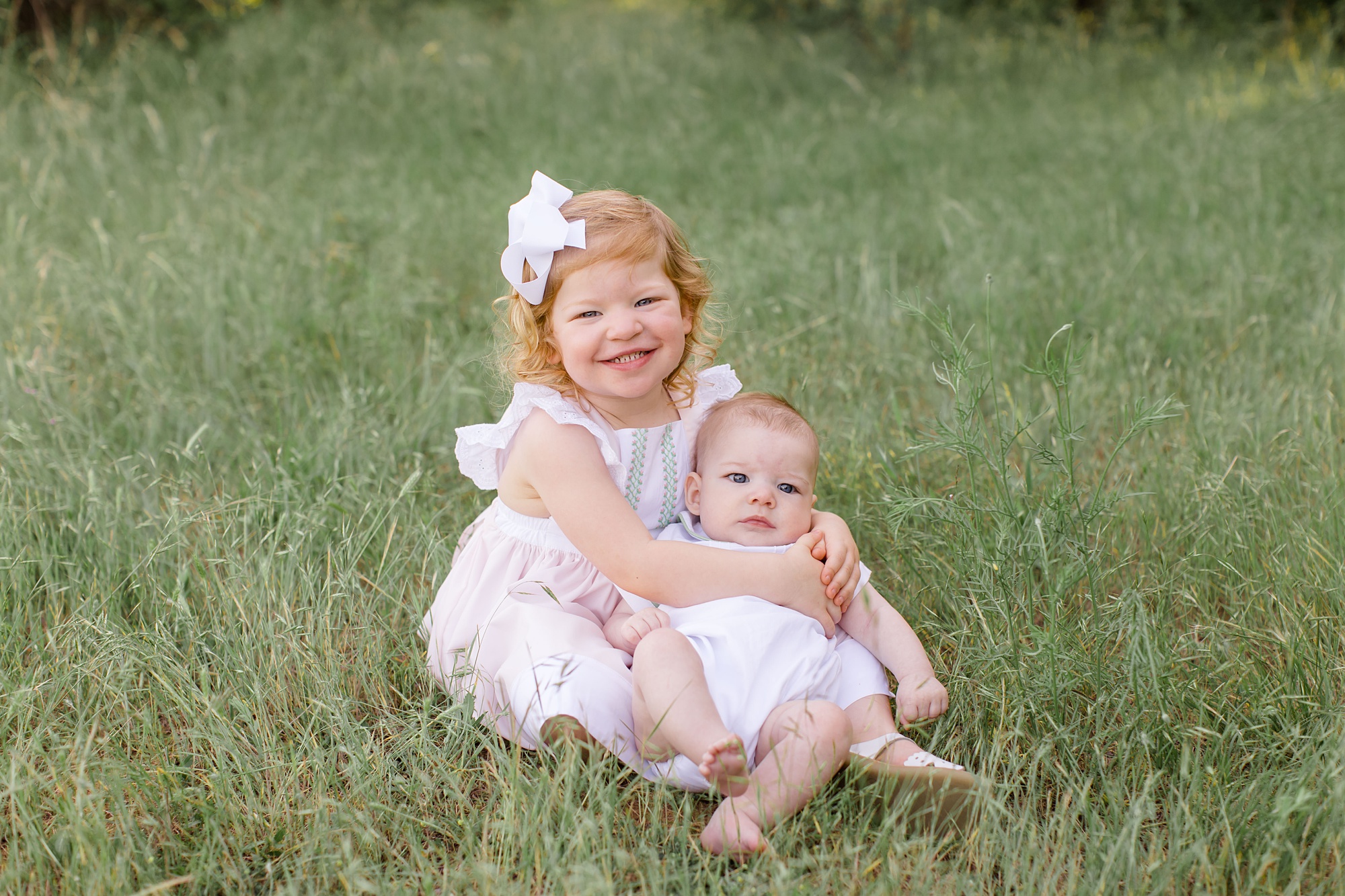 big sister holds baby brother during spring family photos 