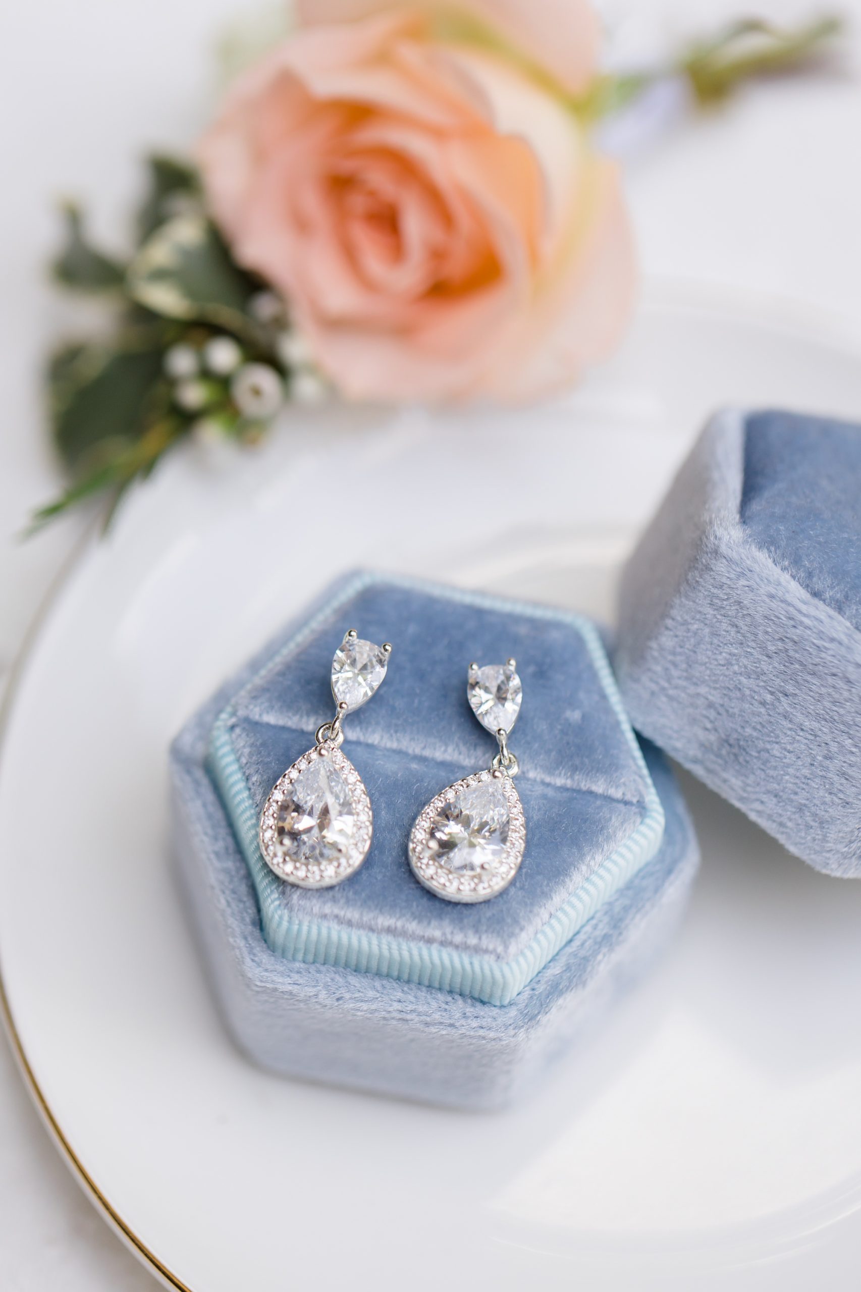 bride's earrings rest in pale blue jewelry box