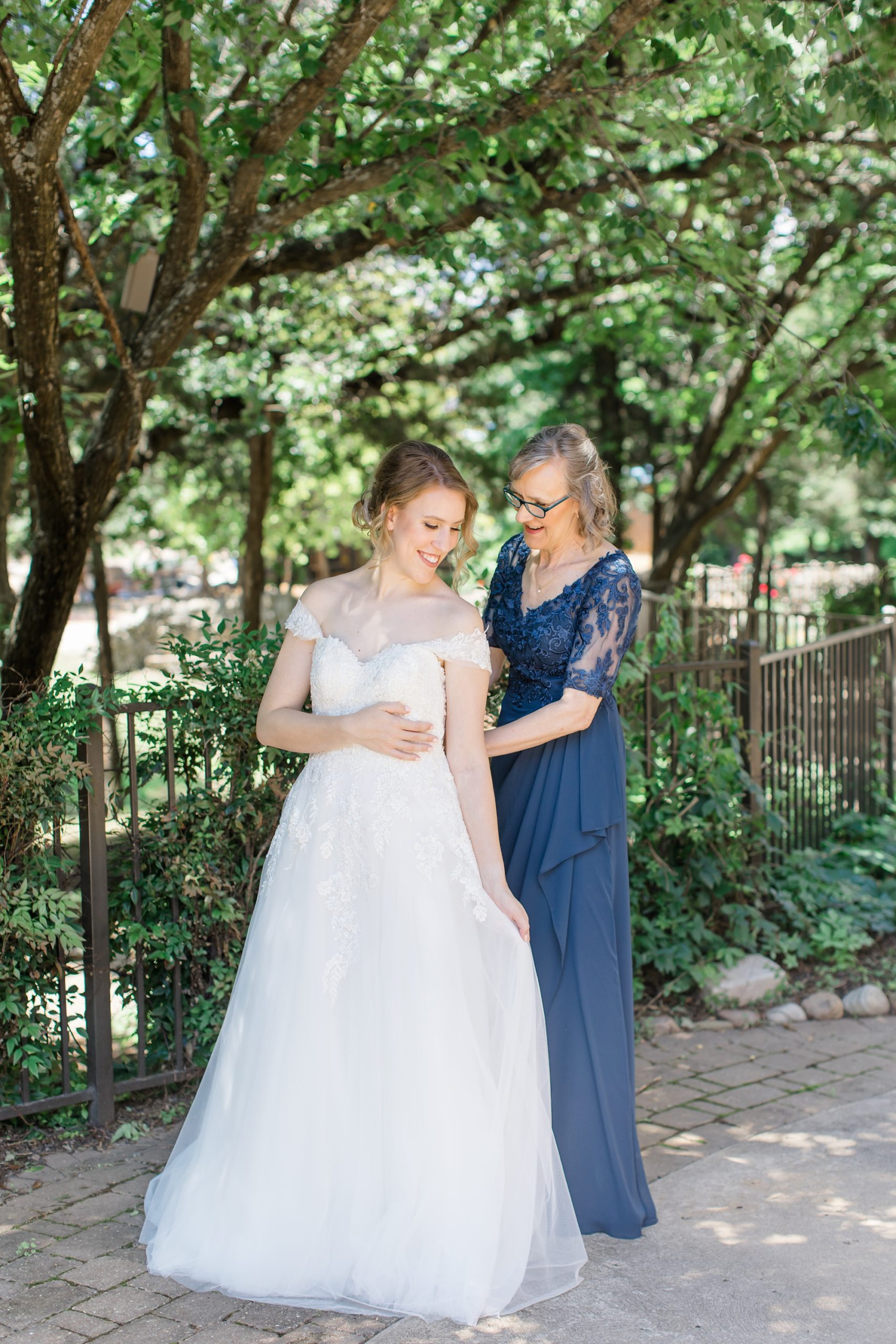 mom helps bride with wedding gown in Texas 