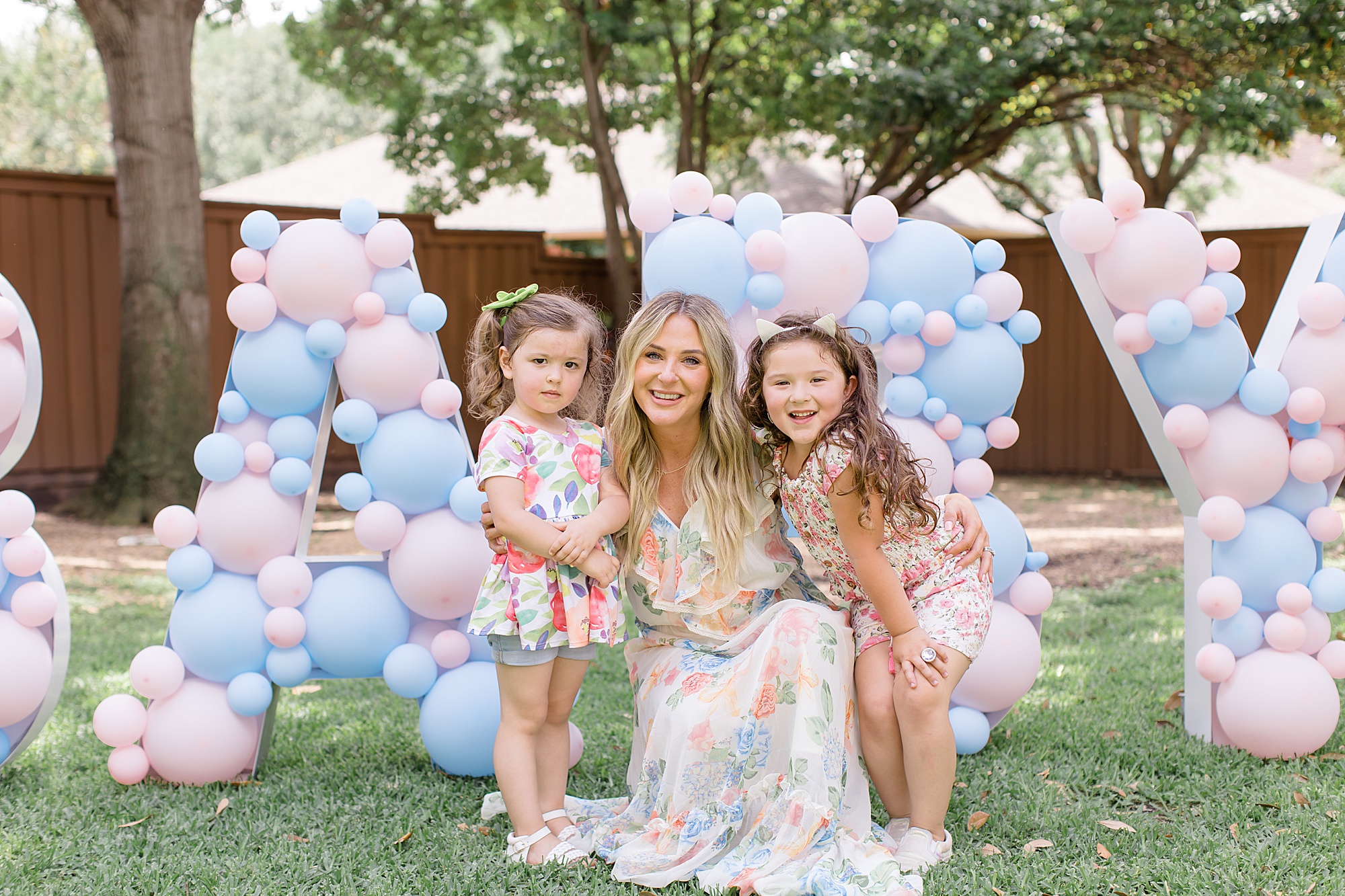 mom-to-be poses with kids in backyard