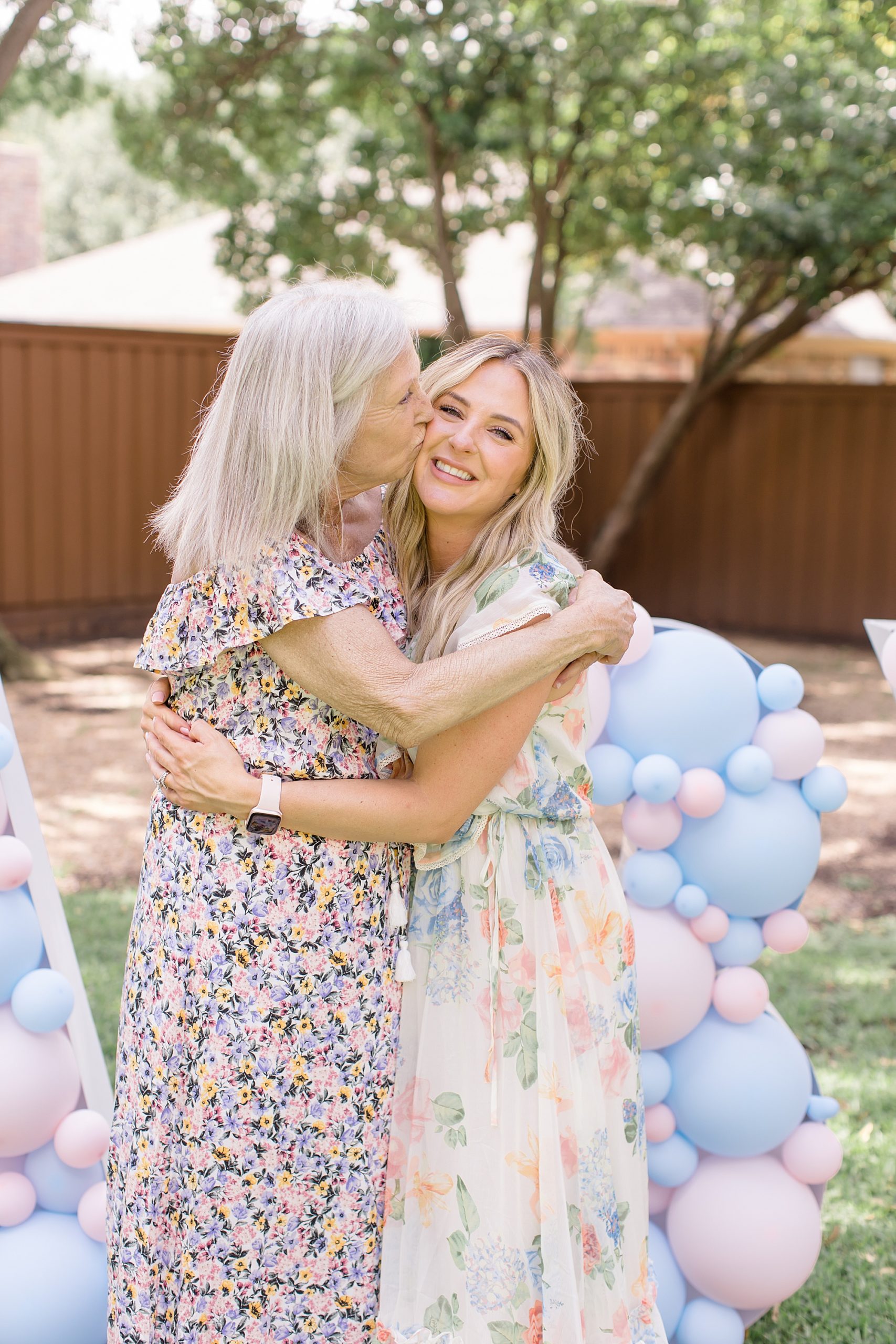 mom hugs daughter during gender reveal party