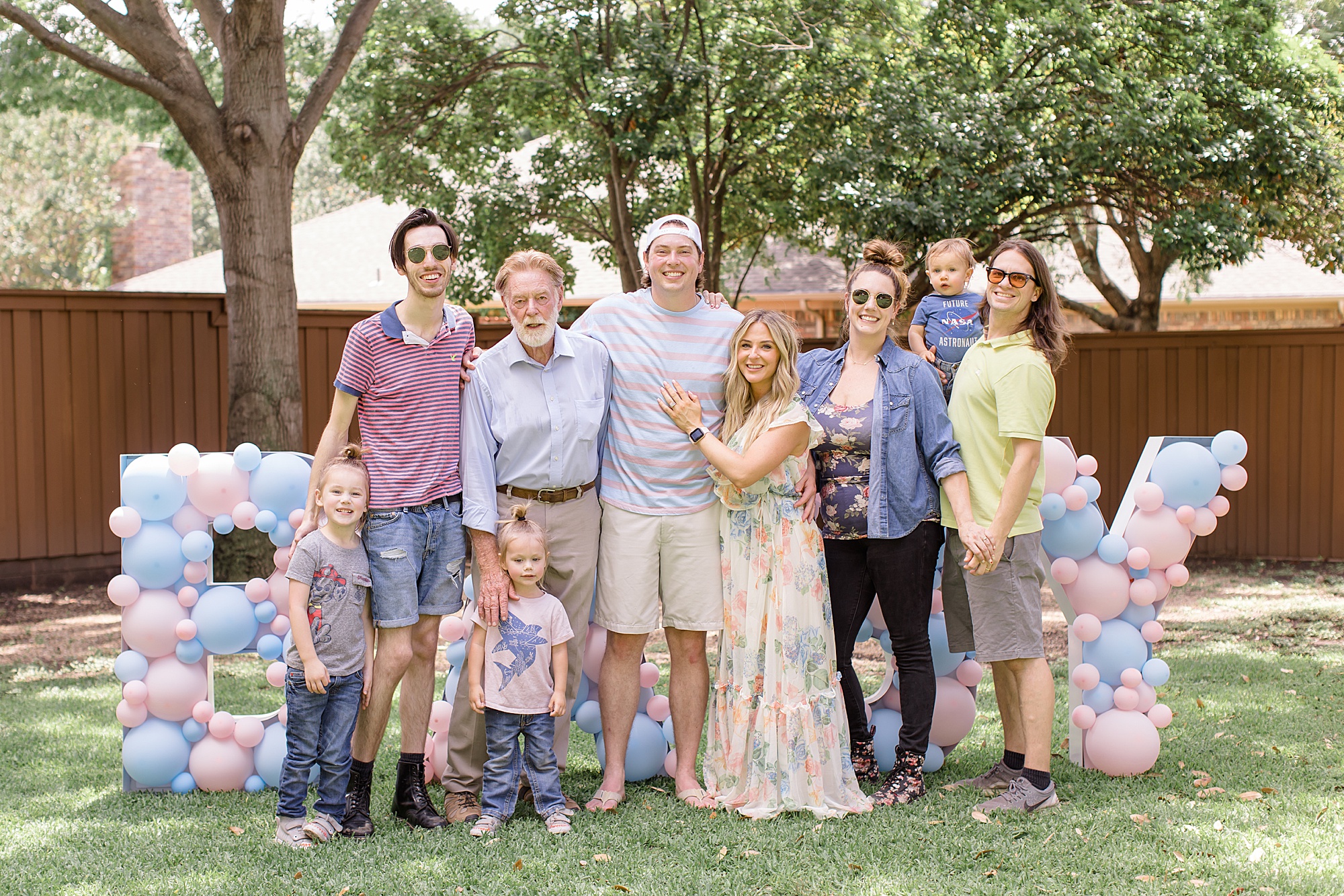 family poses with mom-to-be during gender reveal