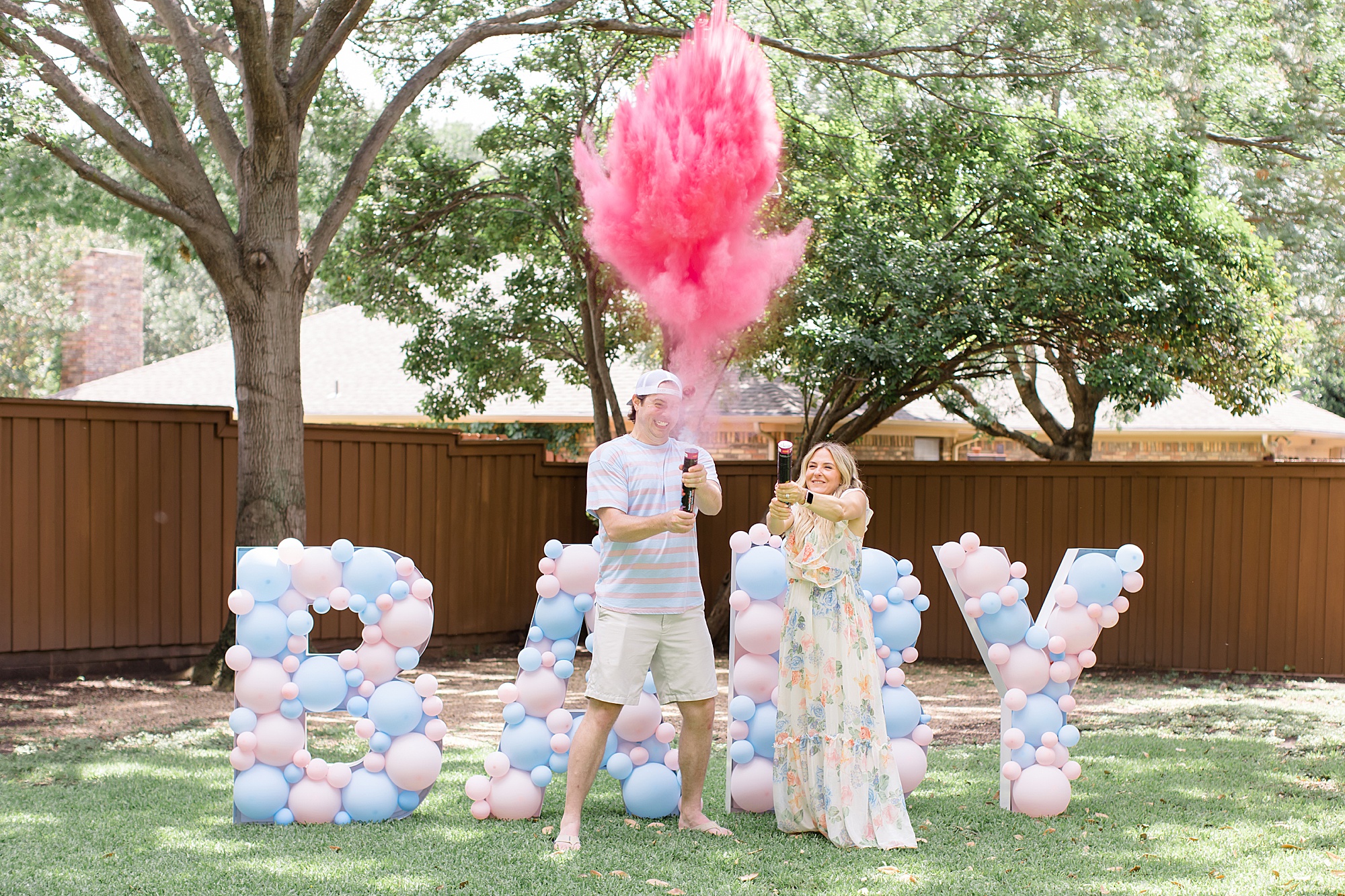 parents pop confetti cannon with pink smoke during Texas gender reveal party