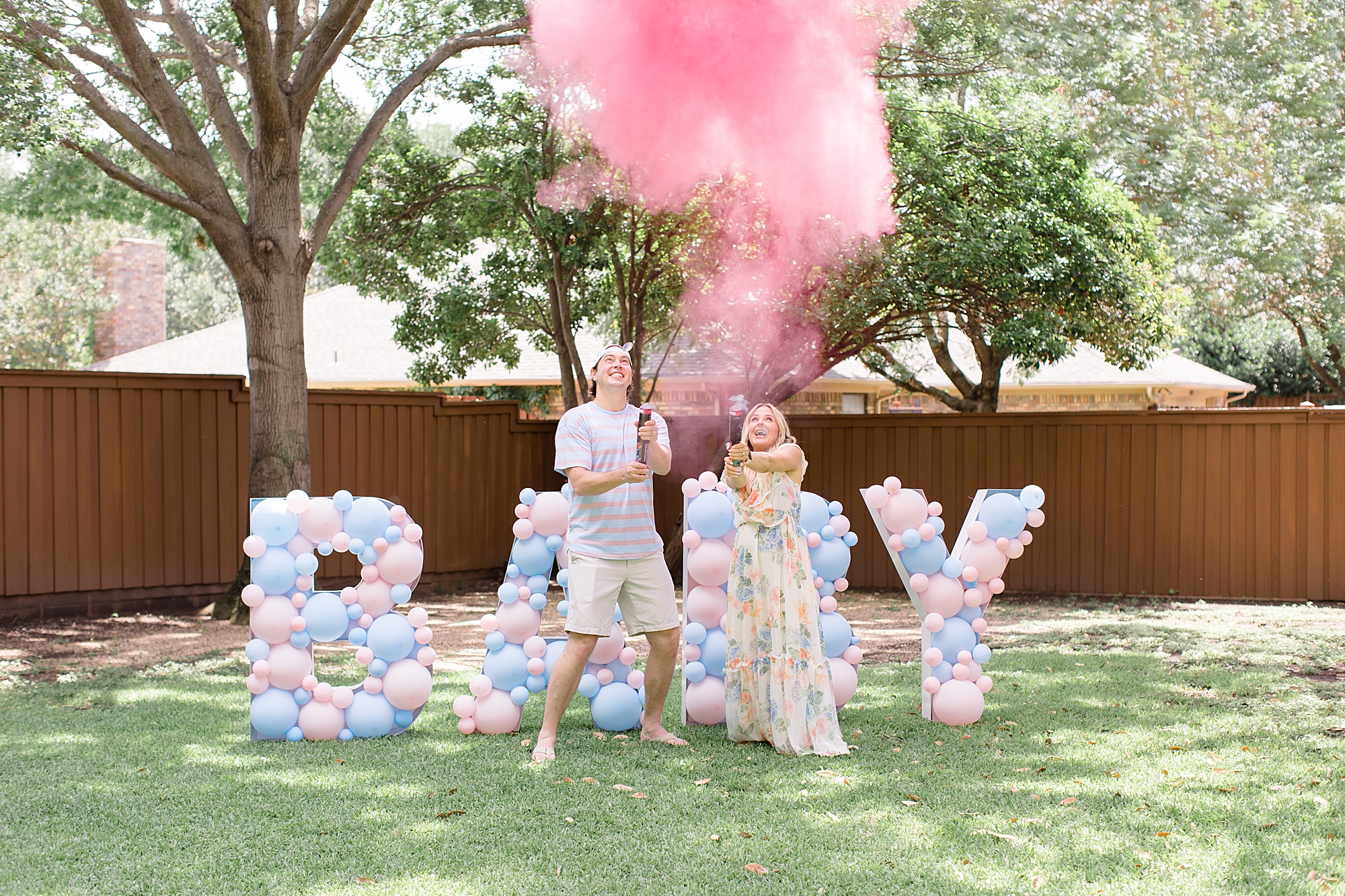 expecting parents pop confetti cannon during gender reveal party