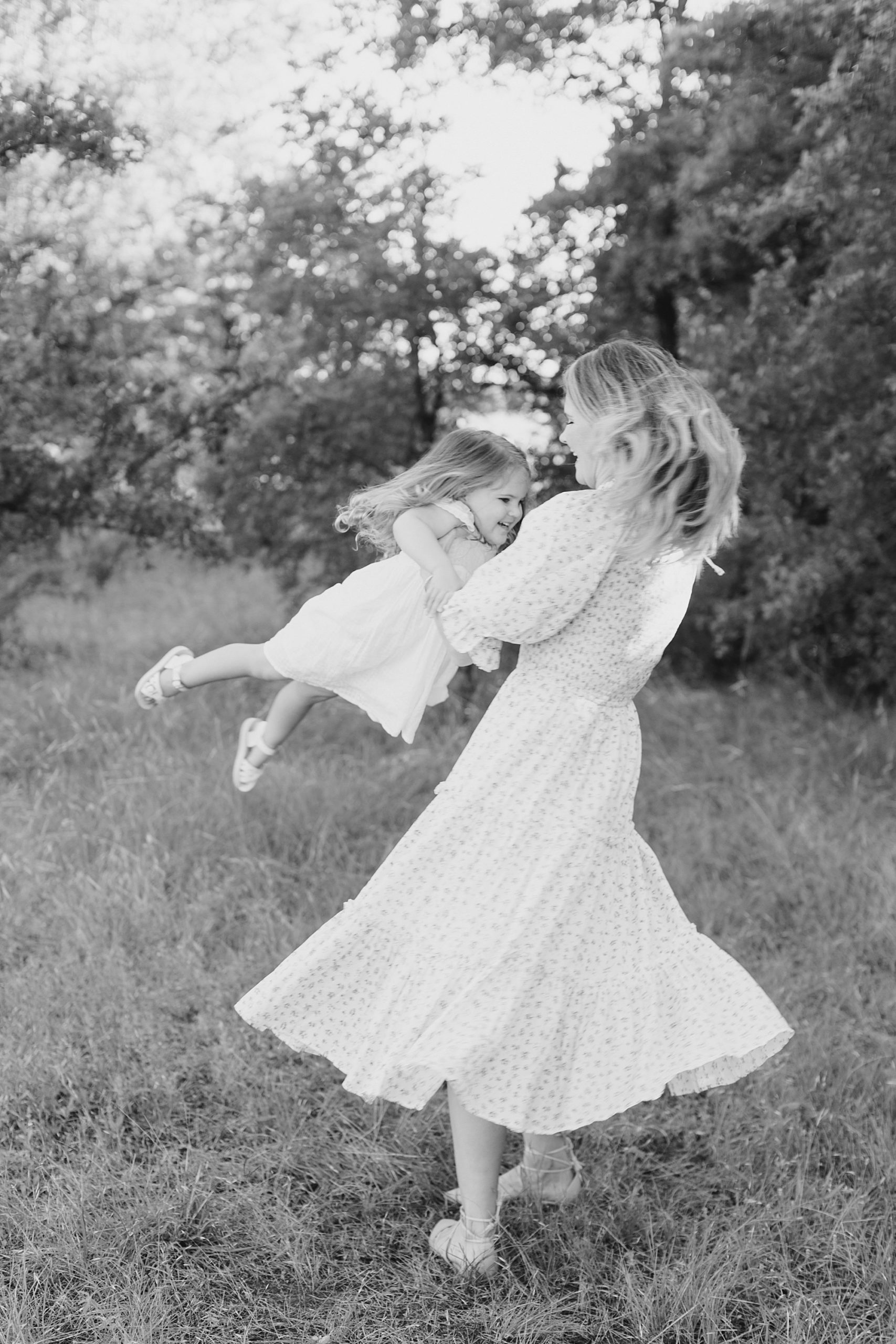 woman swings daughter during spring photos