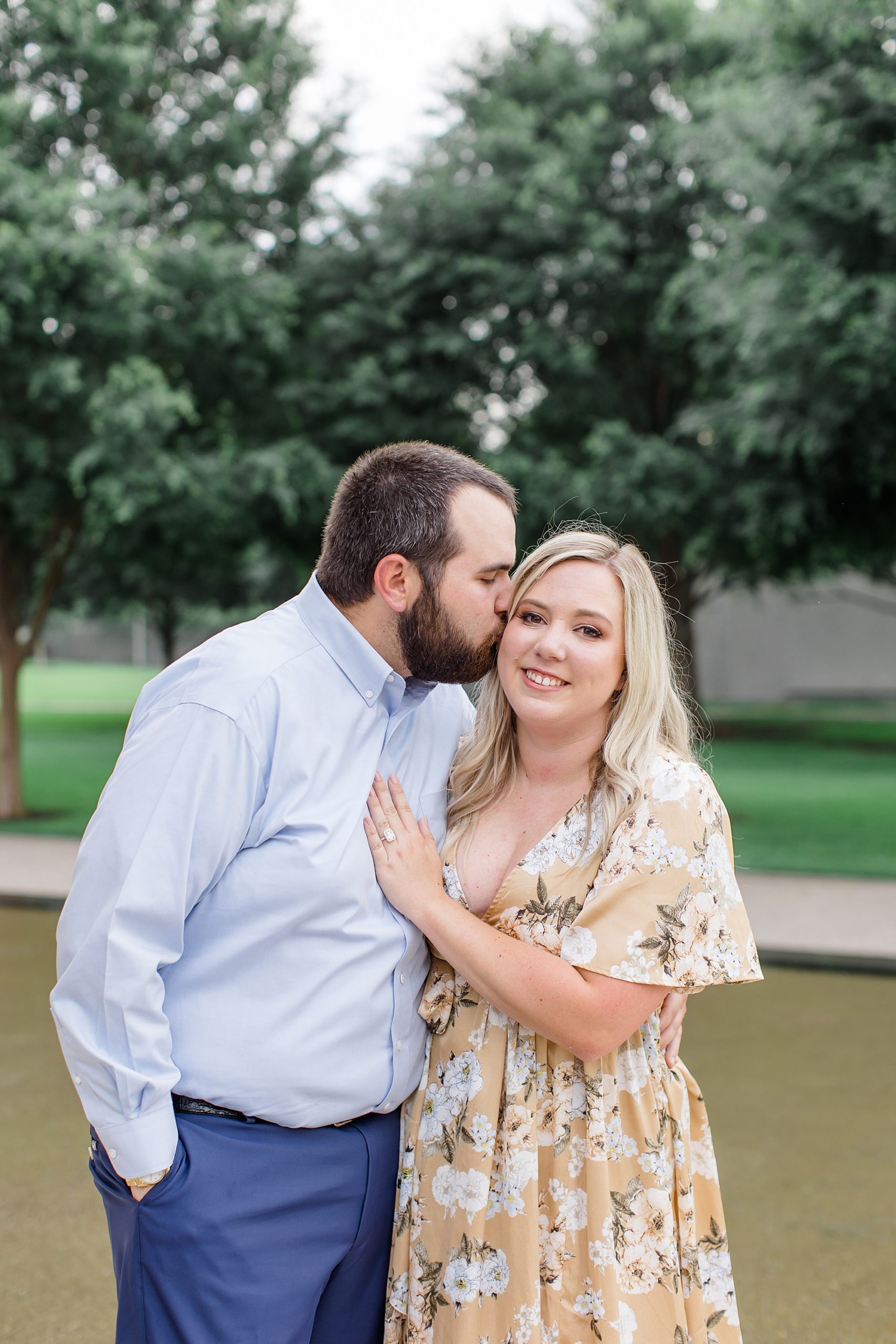 groom kisses bride's cheek during Kimball Art Museum engagement session 