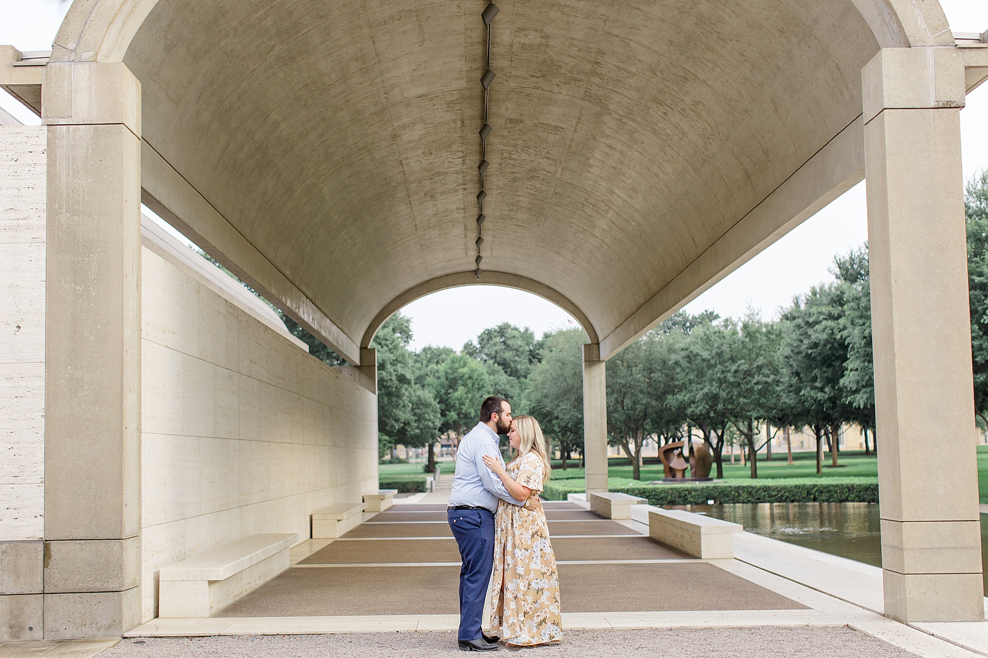 bride and groom pose under awning at Kimball Art Museum