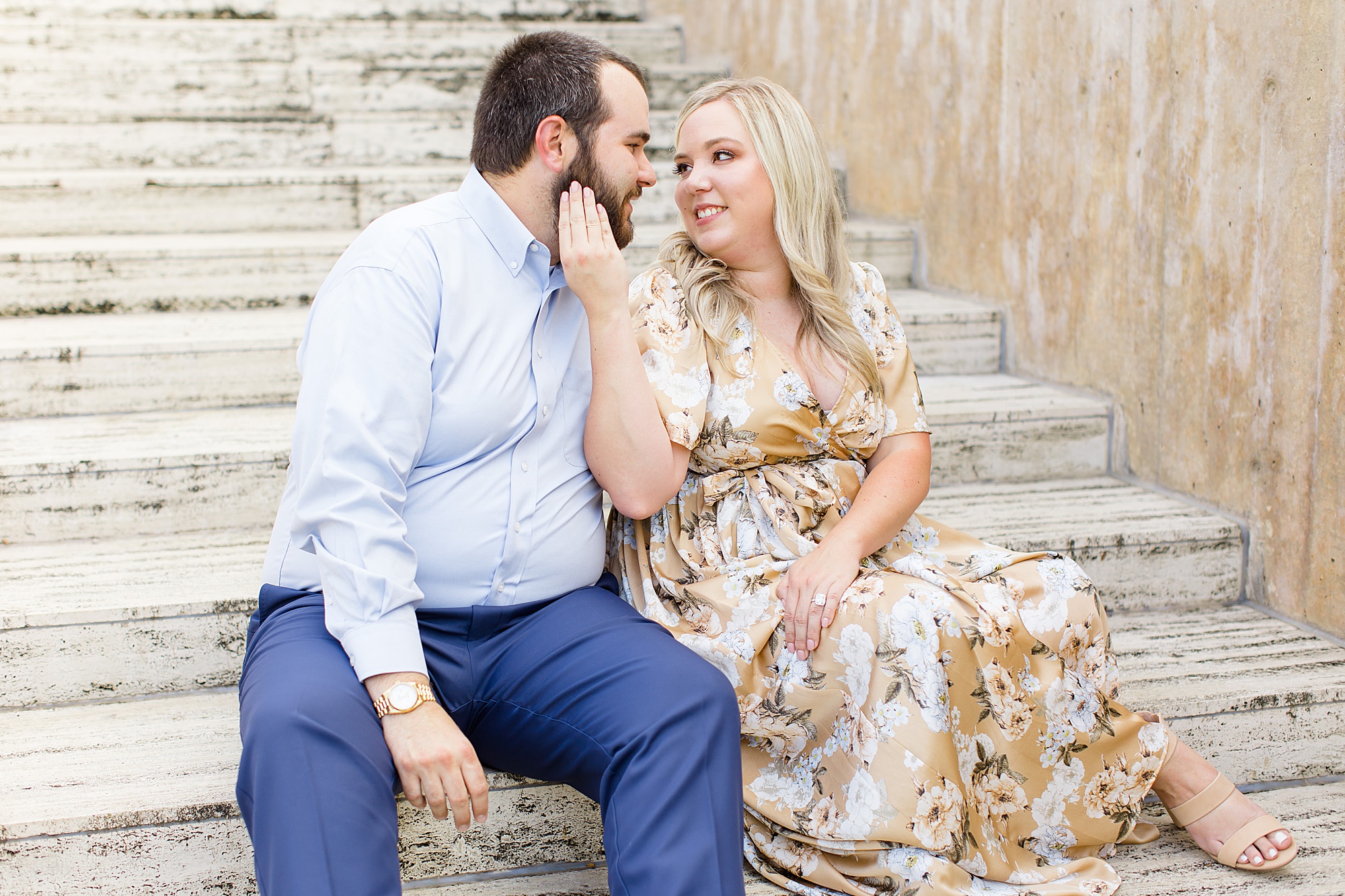 engaged couple hugs during summer engagement session on steps at Kimball Art Museum