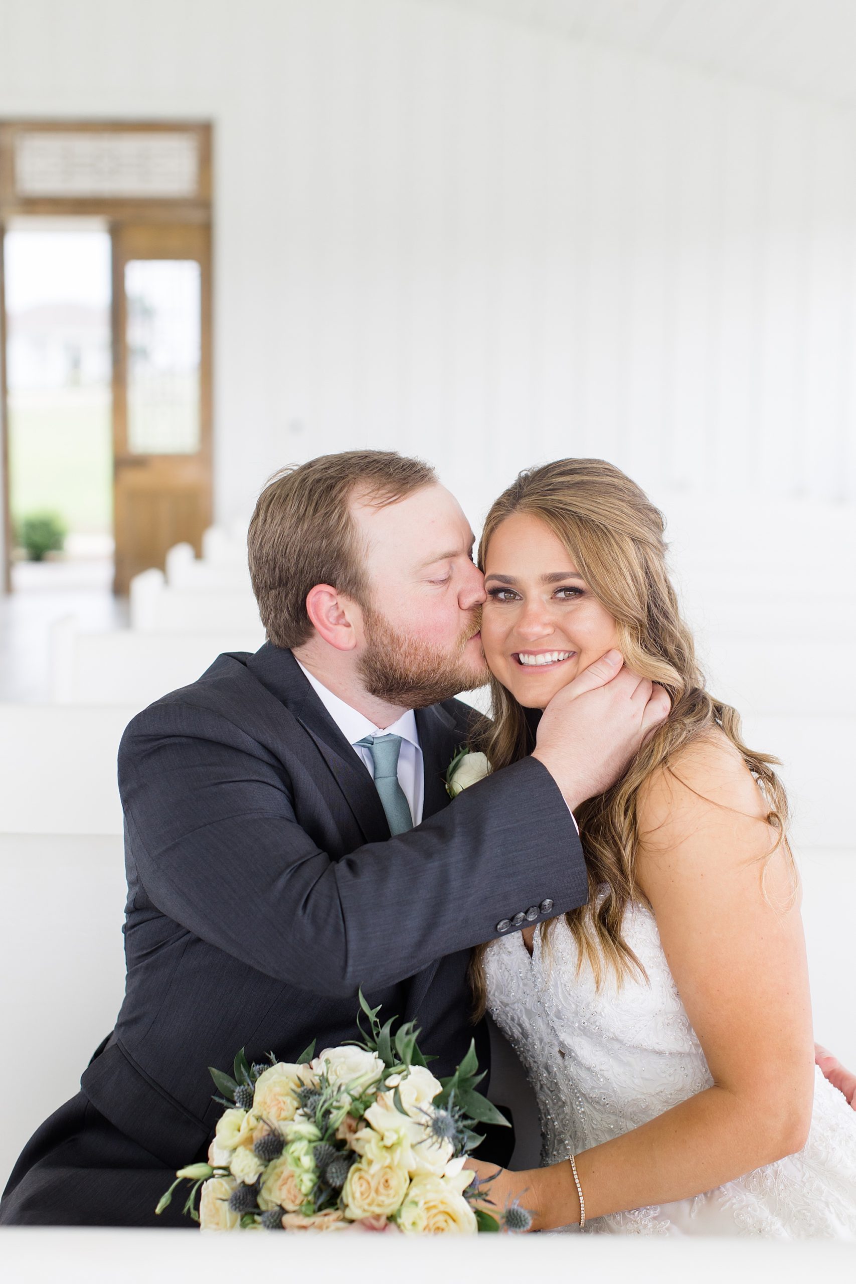 groom kisses bride's cheek at The Grand Ivory