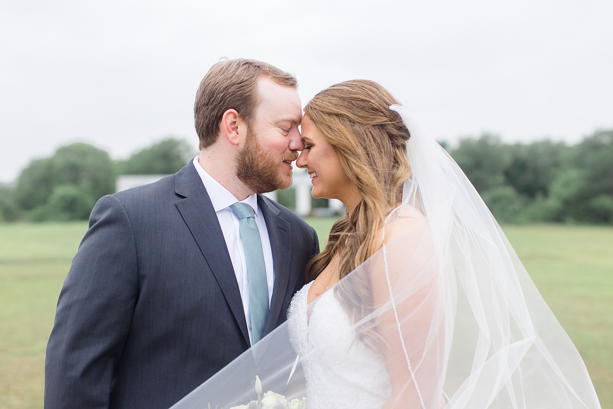 groom kisses bride's forehead during wedding portraits