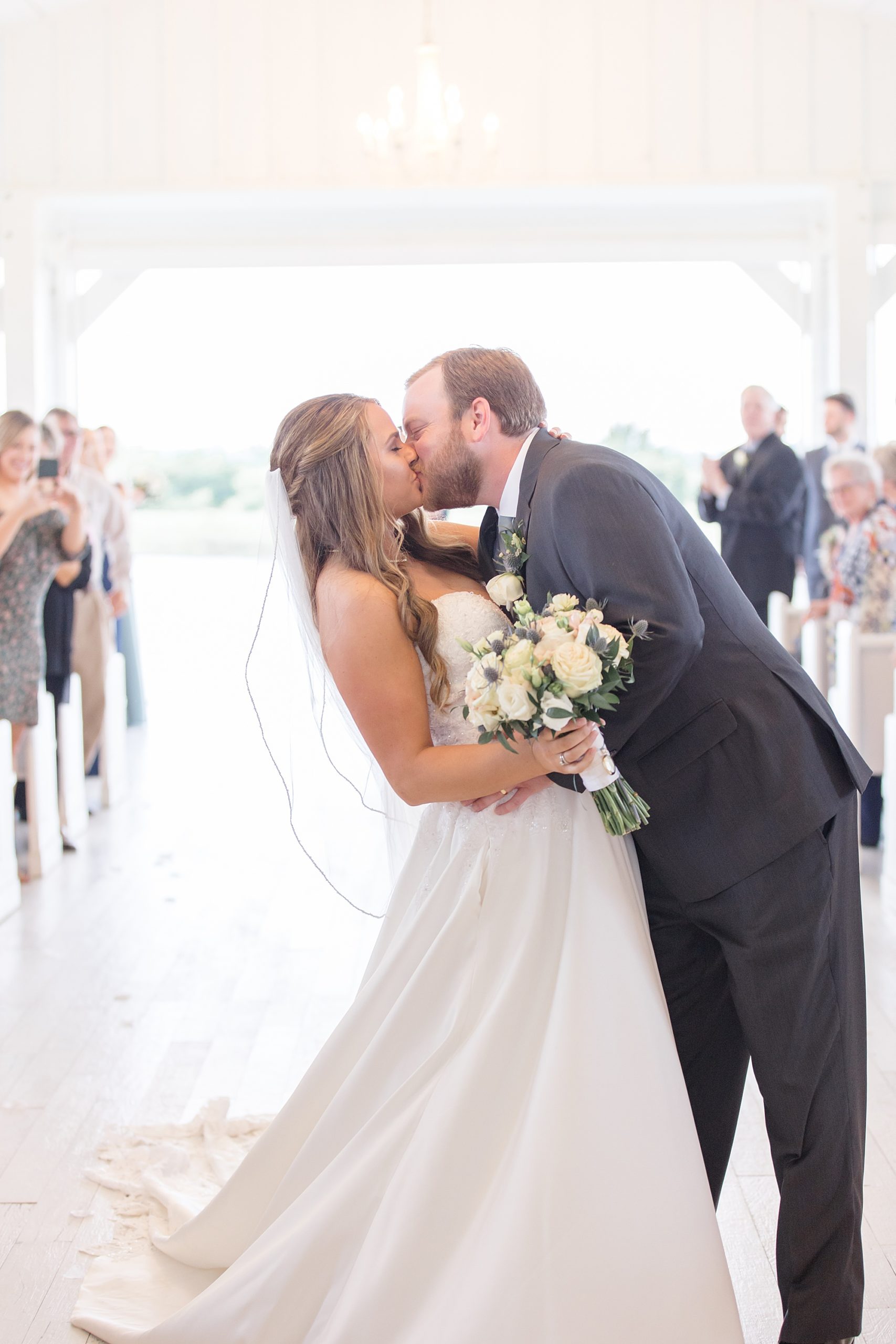 bride and groom kiss at end of aisle after ceremony