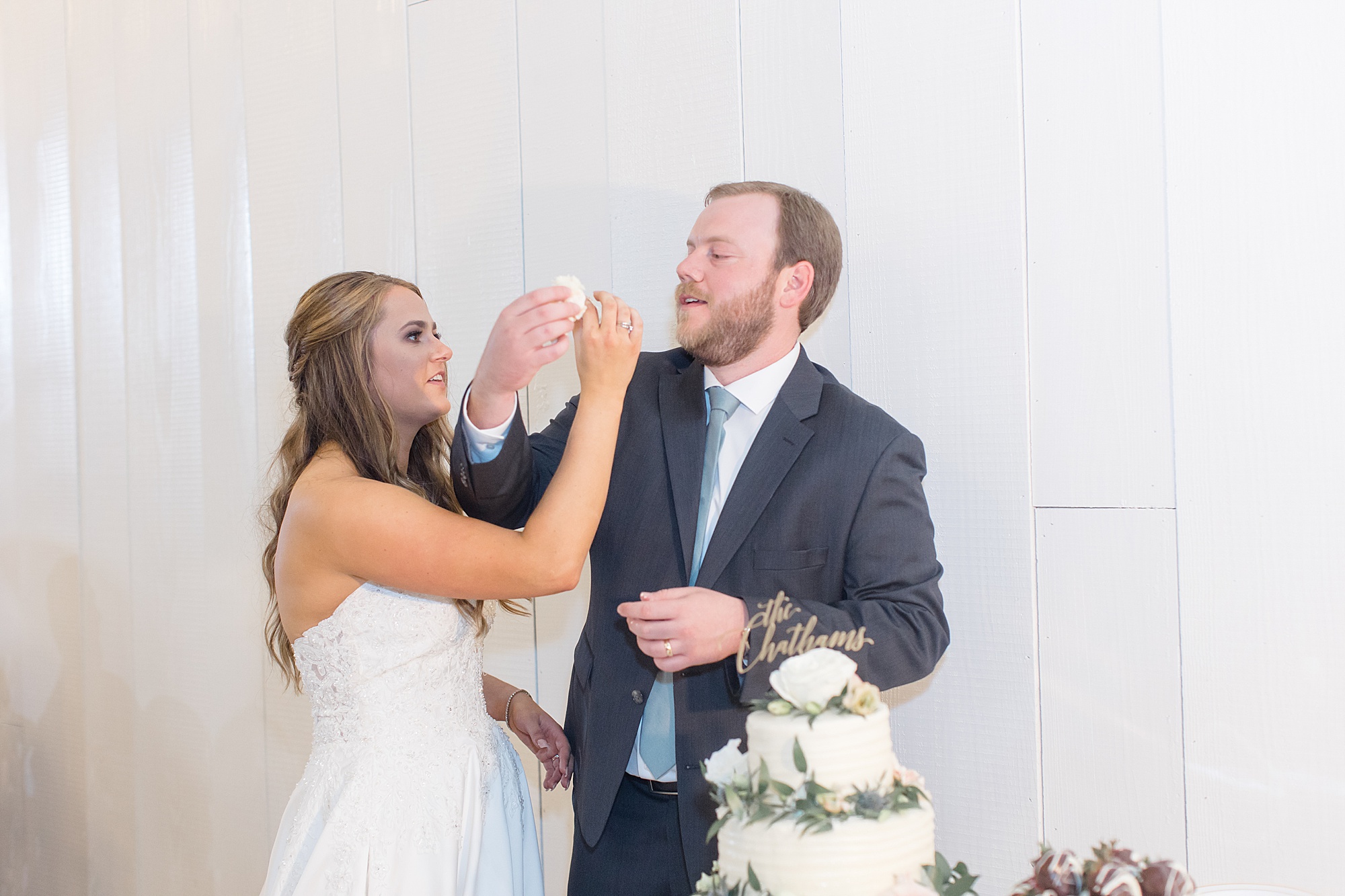 newlyweds feed each other cake during Texas wedding reception
