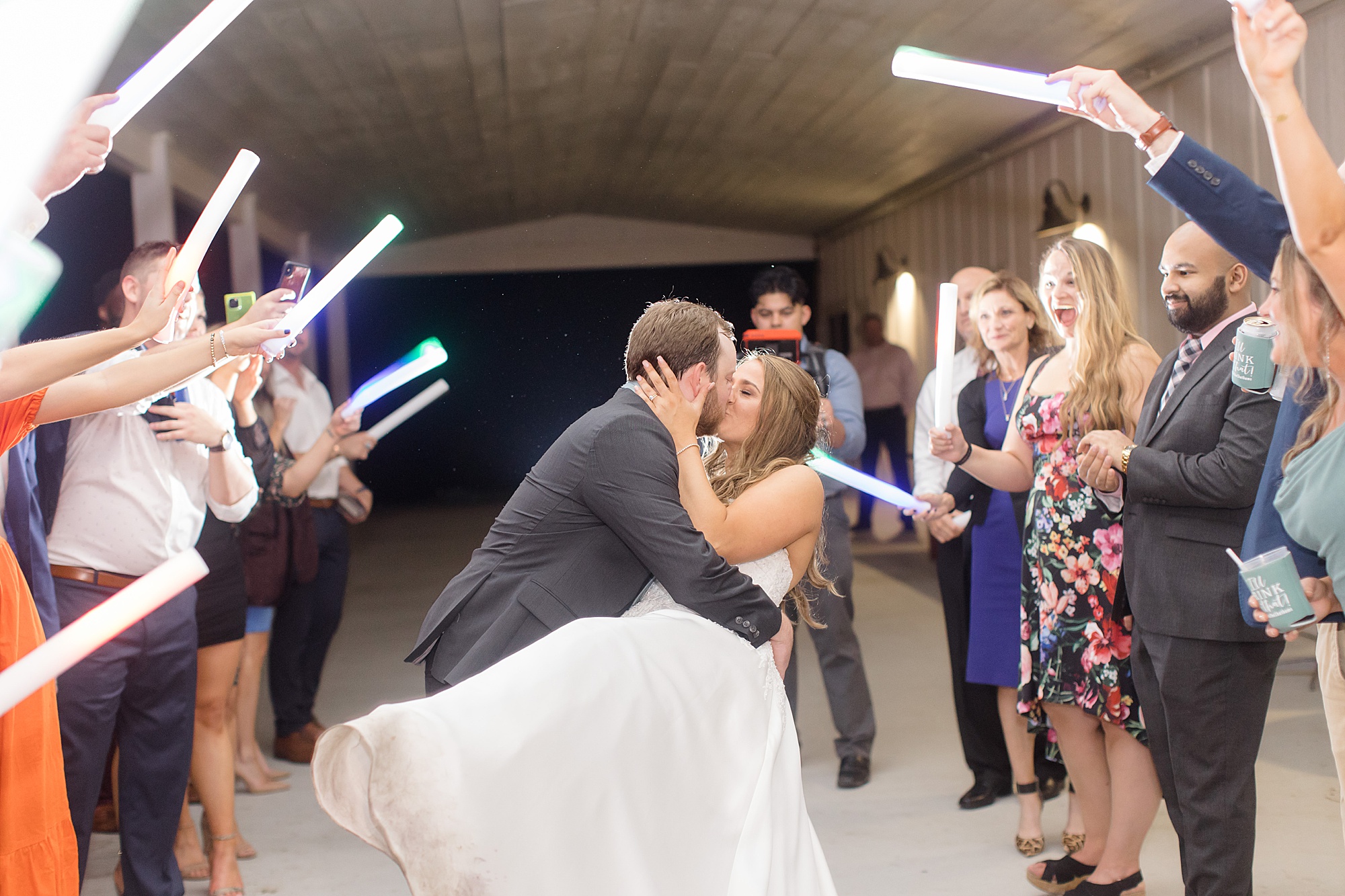 bride and groom kiss during glowstick exit