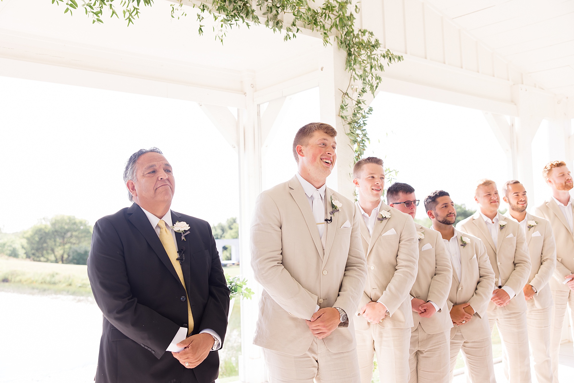 groom watches bride walk down aisle during Texas wedding ceremony