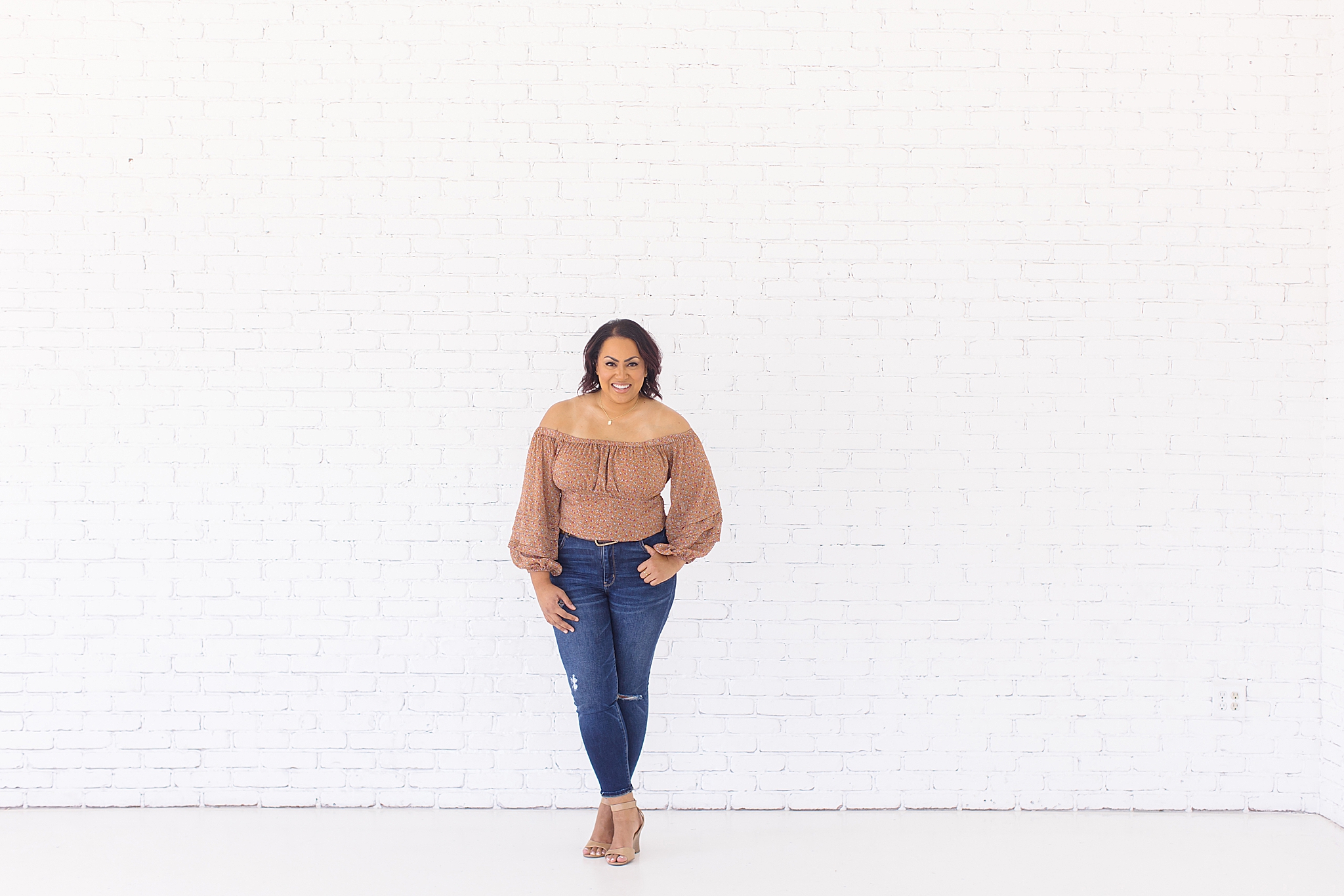 woman stands against white wall during Branding session at the Lumen Room