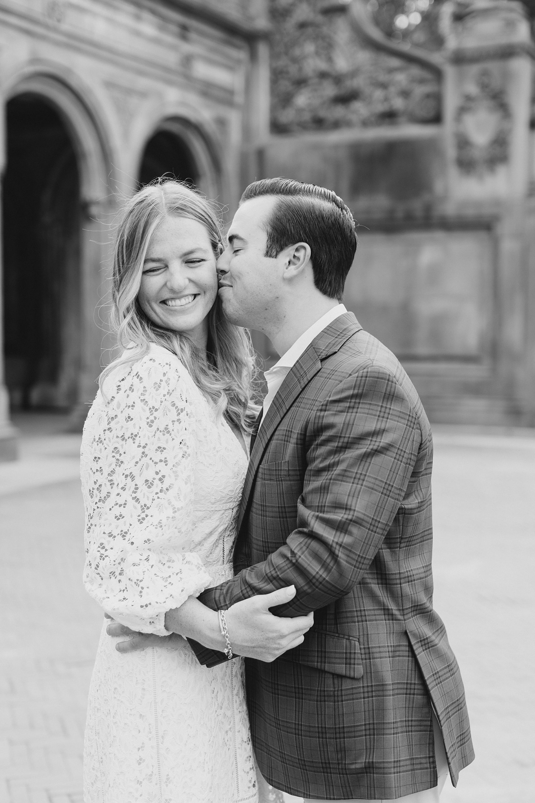 groom kisses bride's cheek during NYC engagement photos 