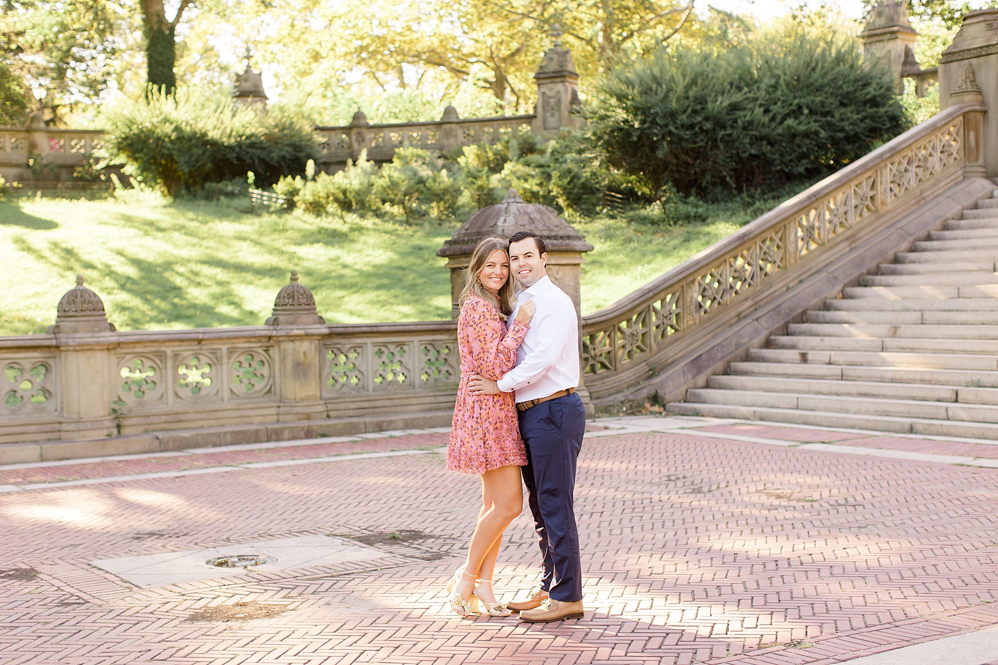 engaged couple hug by staircase in Central Park