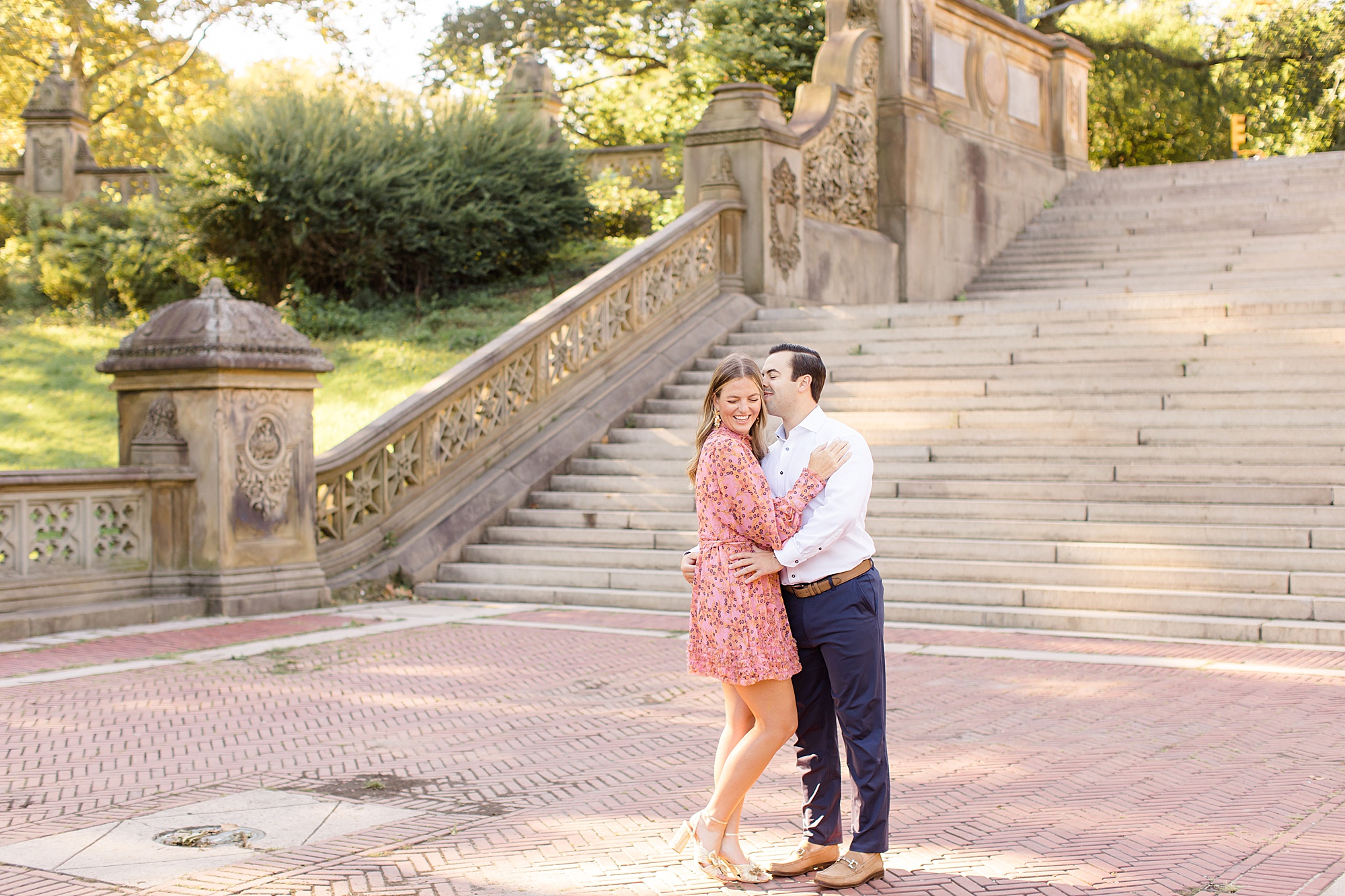 groom kisses bride by steps at Central Park