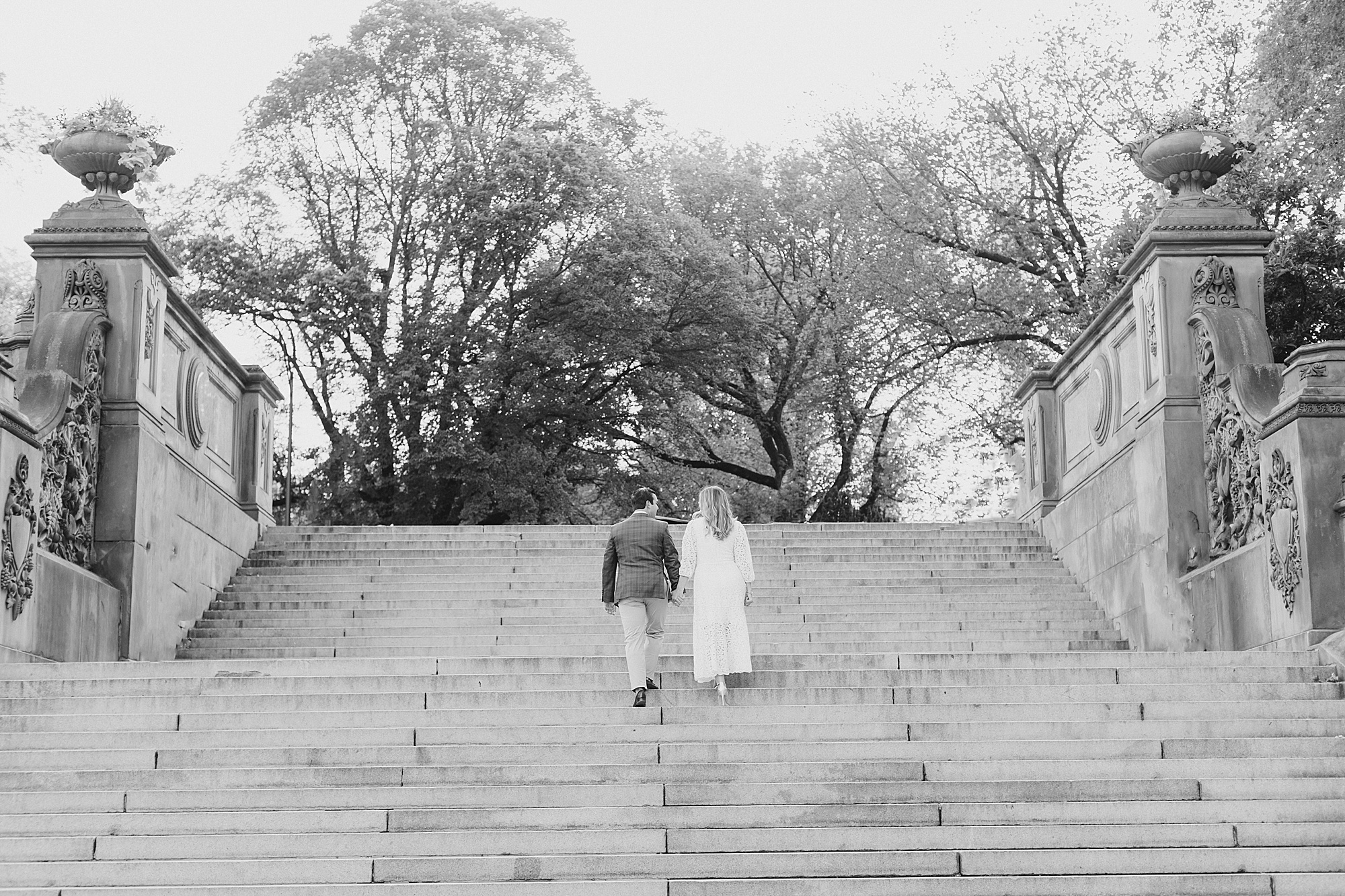couple walks up steps in Central Park
