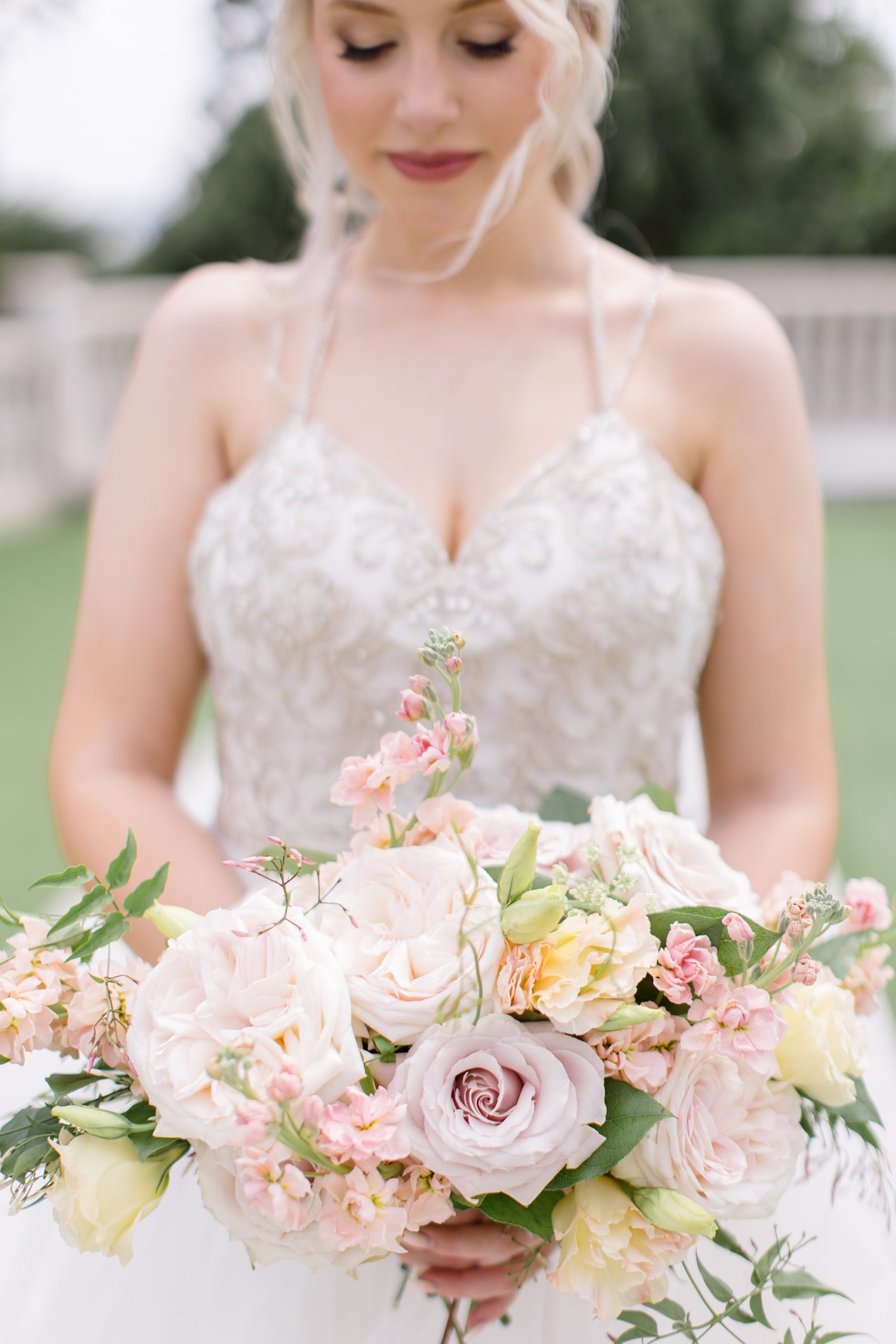 bride holds bouquet of pink and yellow flowers 