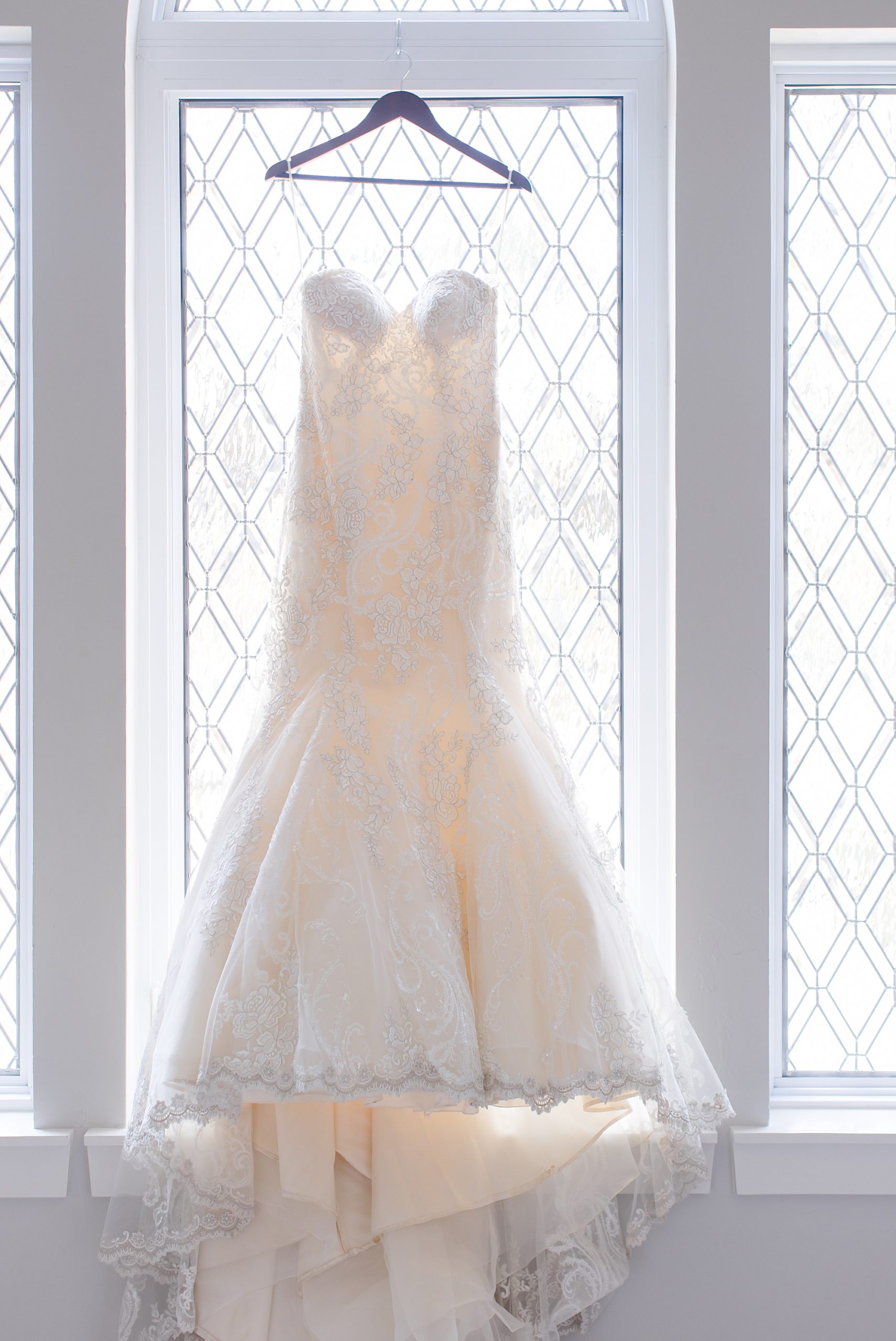 wedding dress hangs in window at Bella Cavalli
