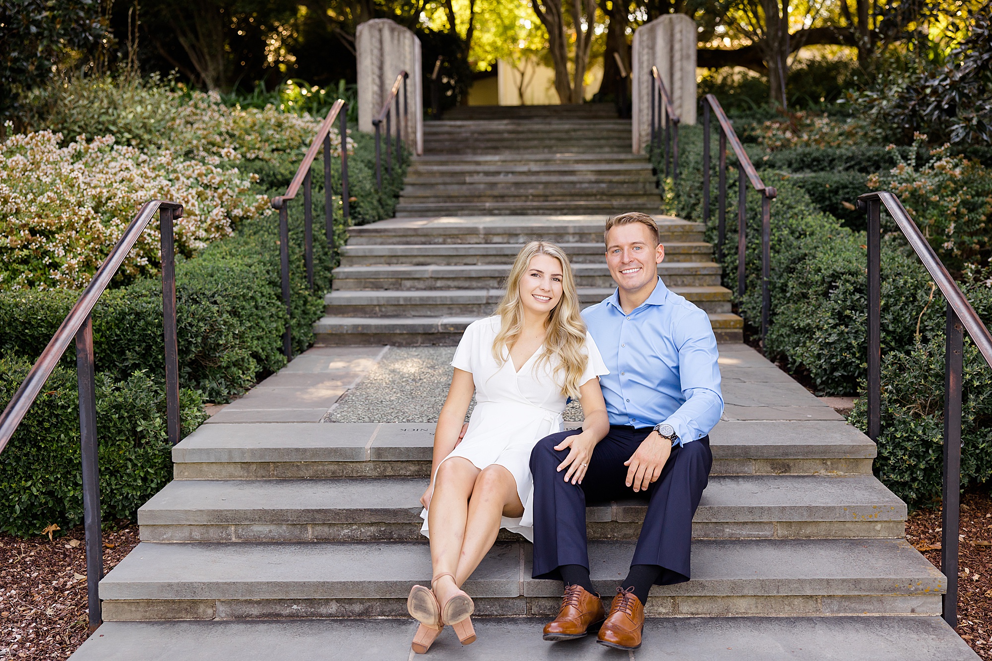 couple sits on steps at Dallas Arboretum