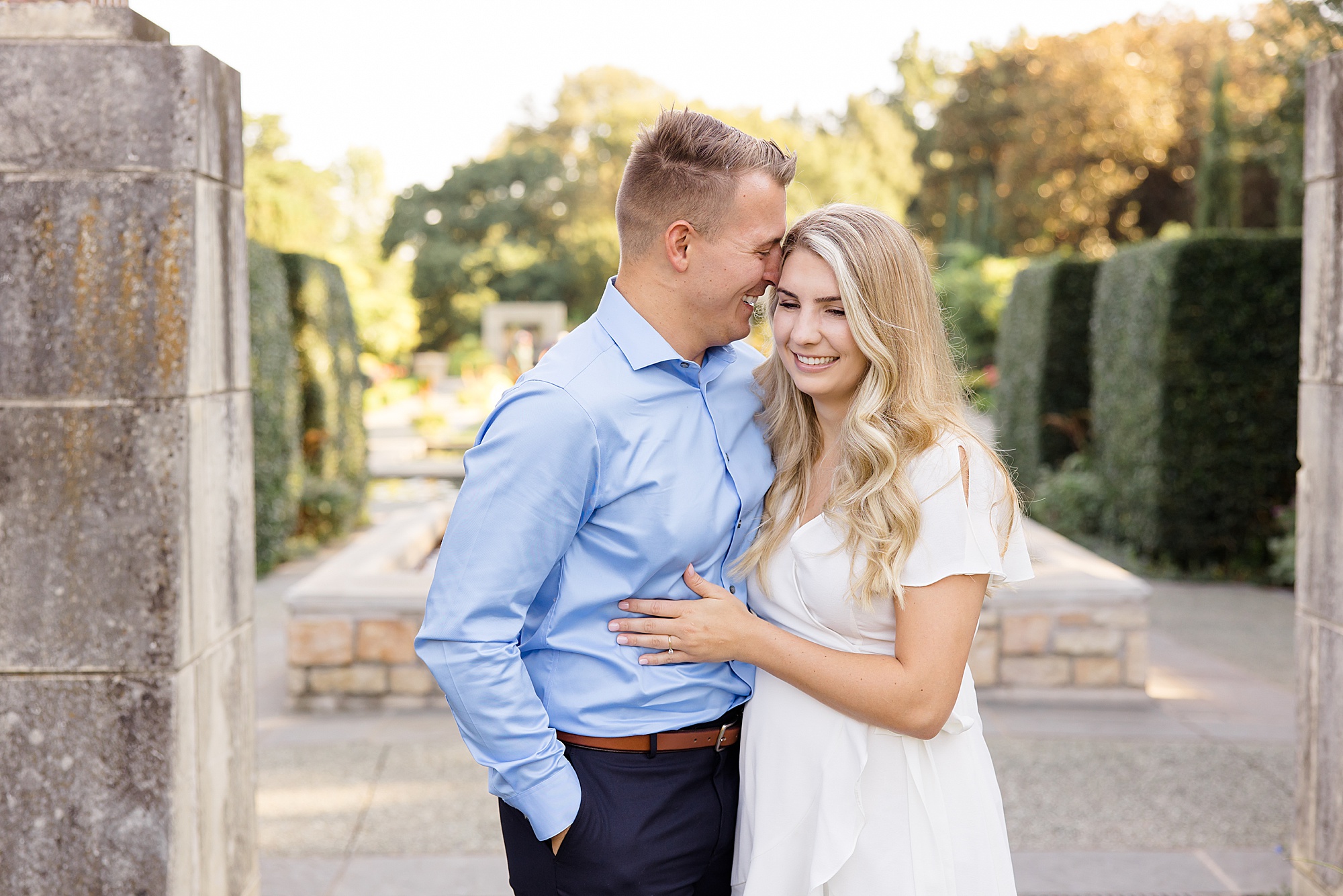 bride and groom laugh during Dallas Arboretum engagement portraits
