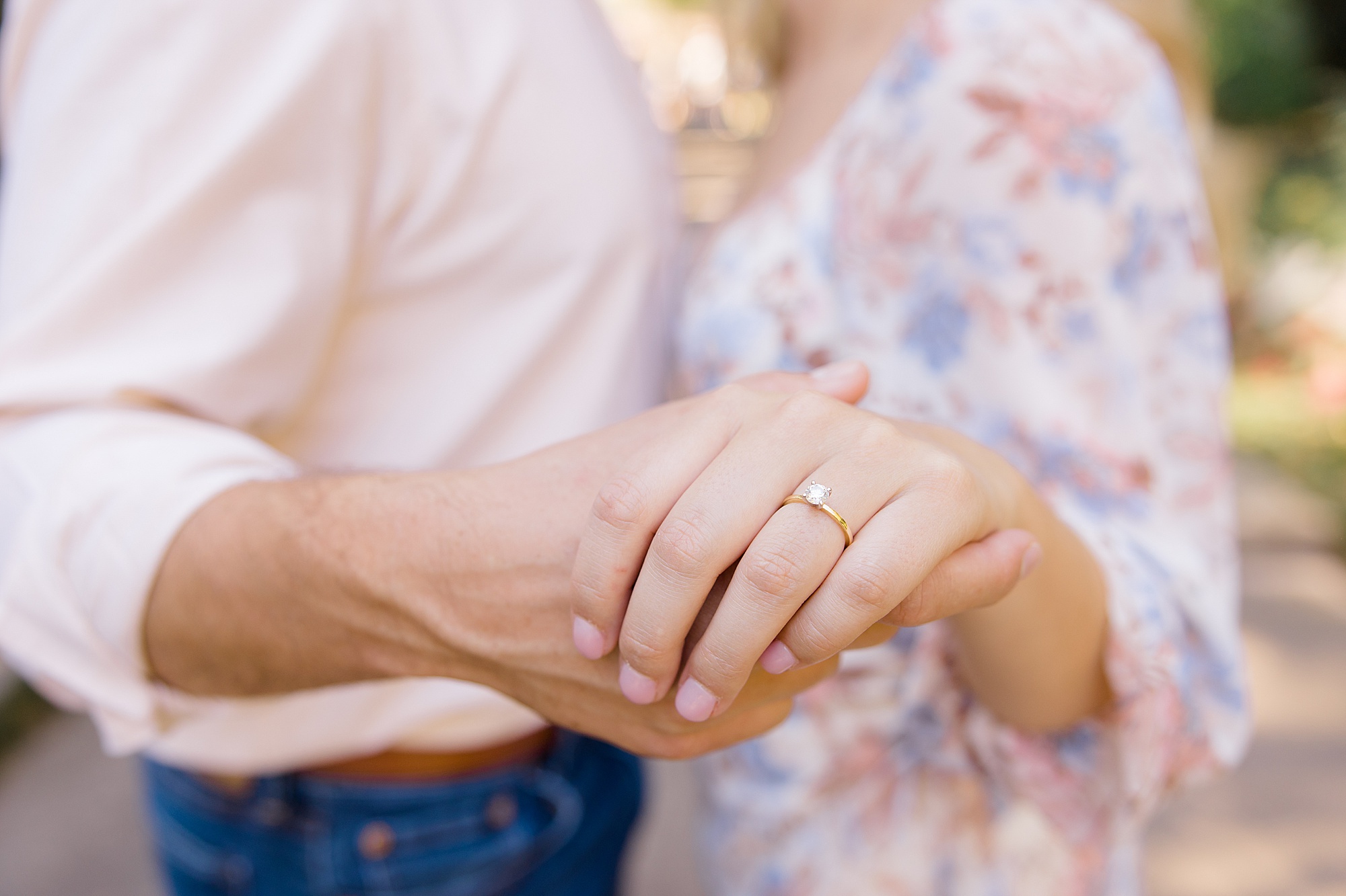 bride and groom hold hands showing off engagement ring