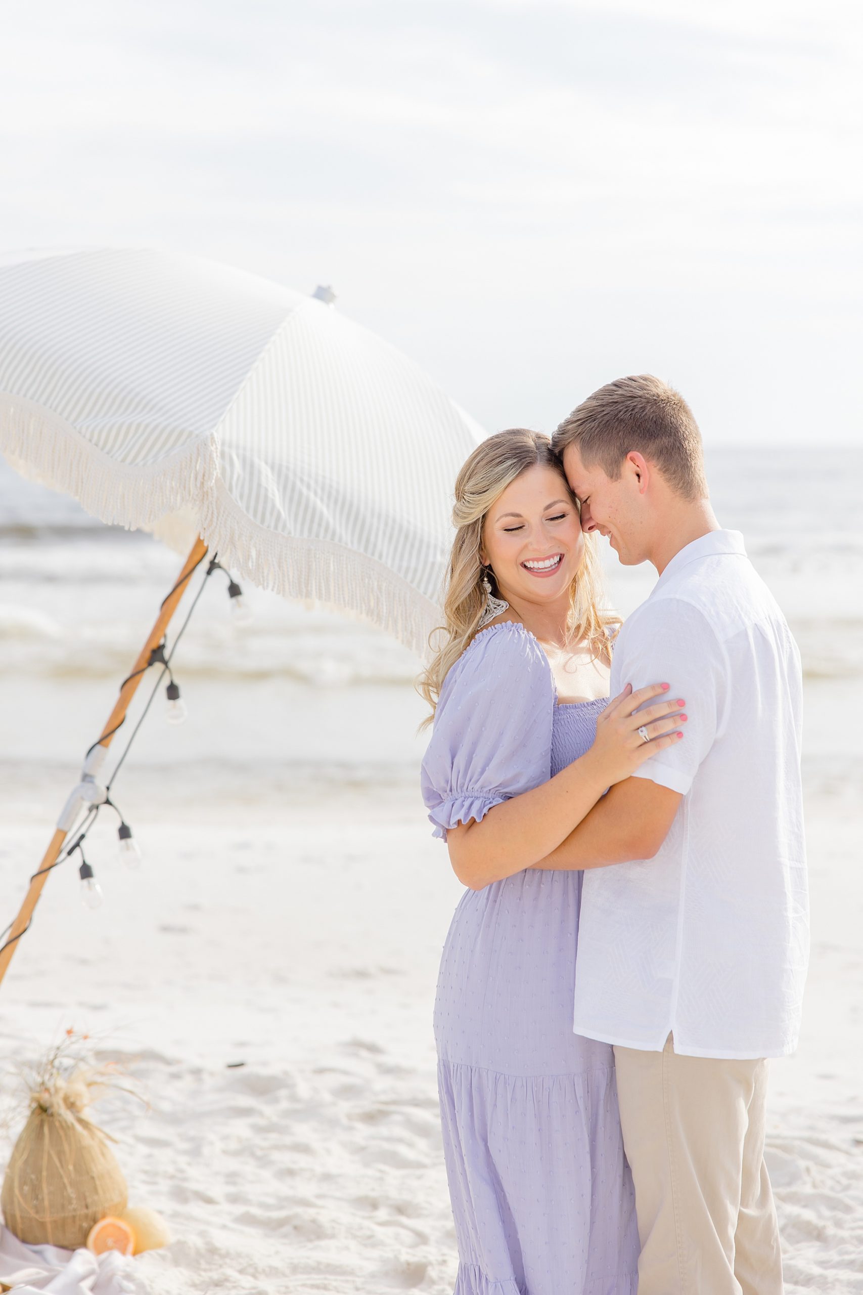 couple poses by umbrella on Rosemary Beach