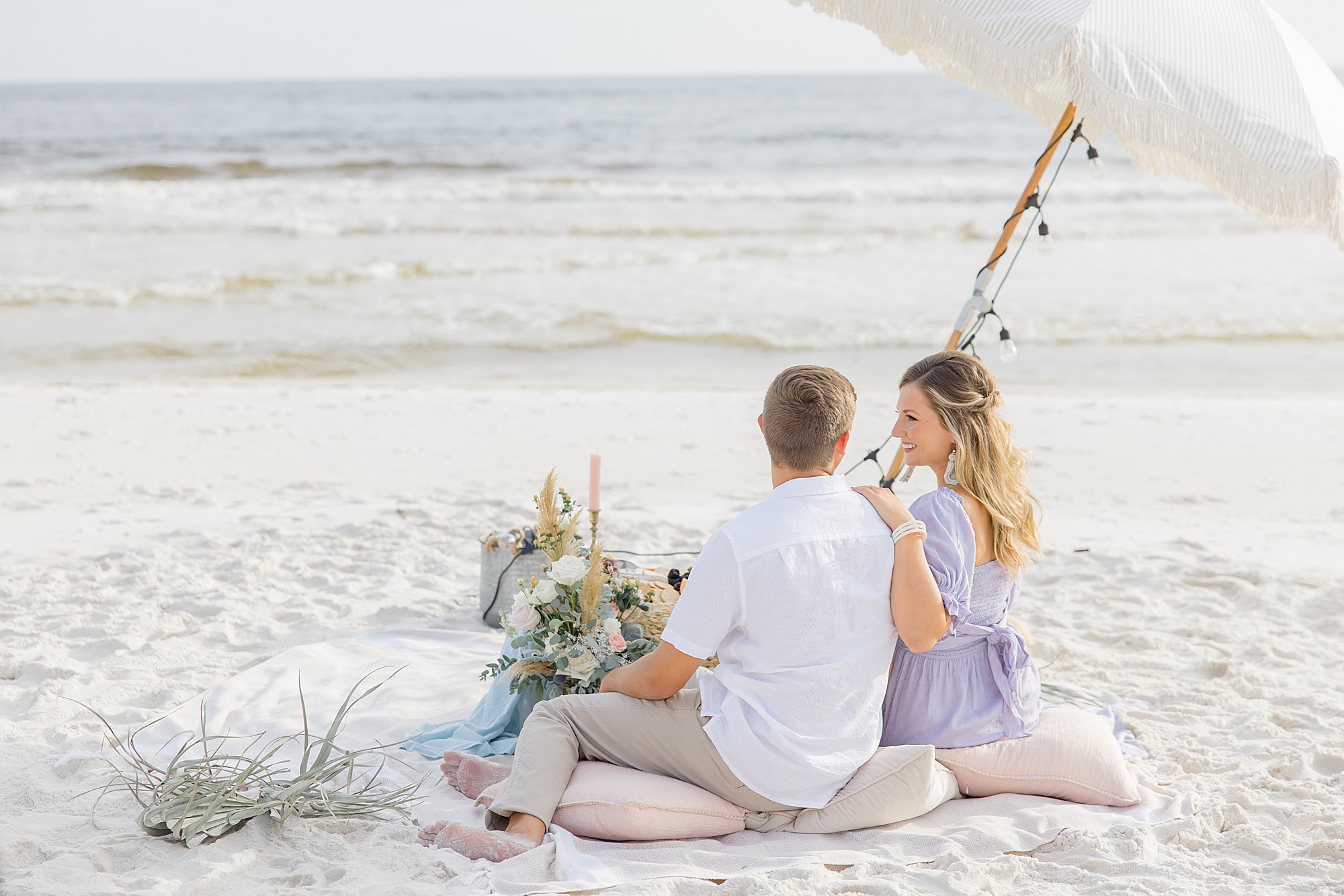 couple sits on pillows during Rosemary Beach engagement session