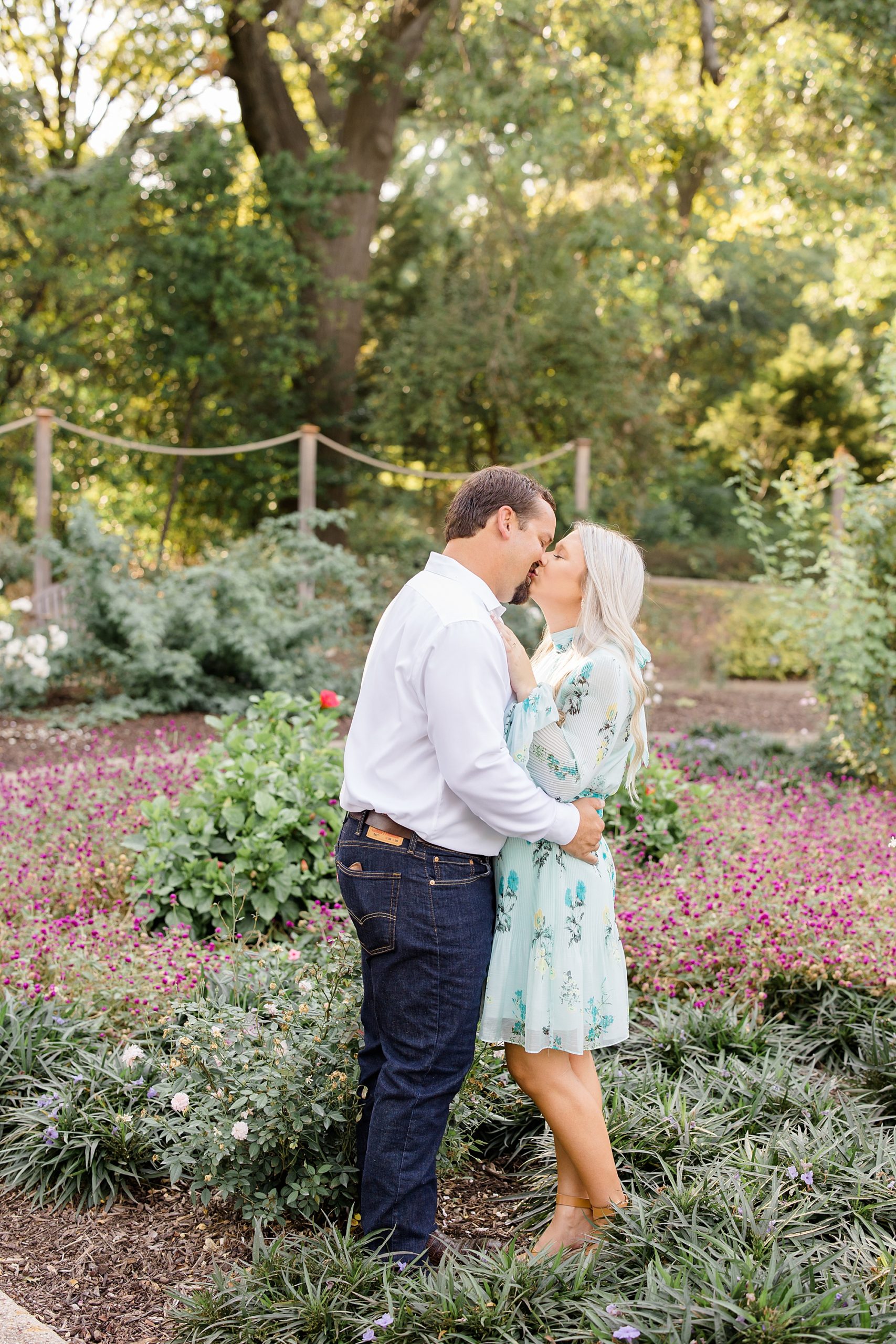 bride and groom kiss by pink flowers at Kimball Art Museum