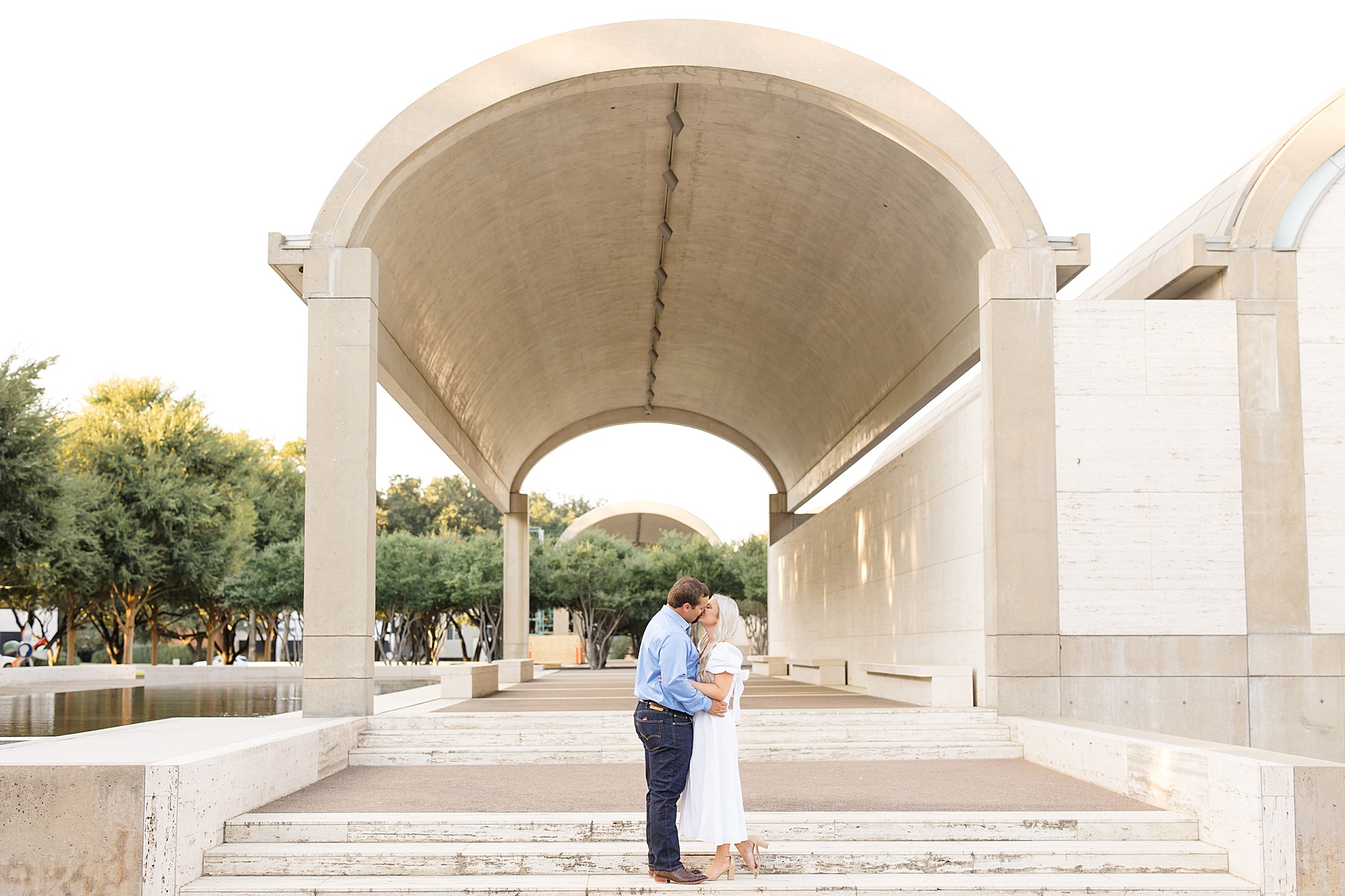 bride and groom hug under covered walkway in Dallas TX