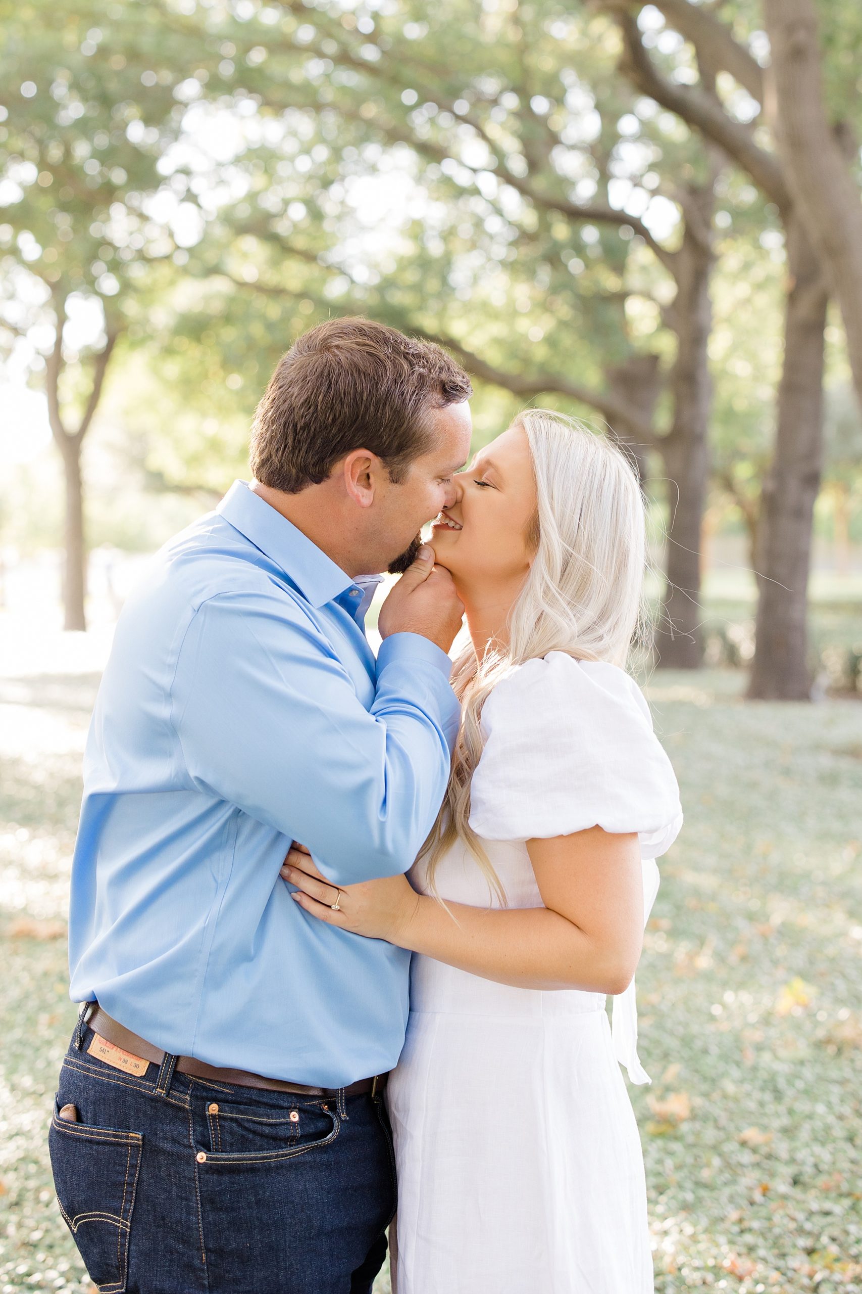 bride and groom kiss among trees in Dallas TX