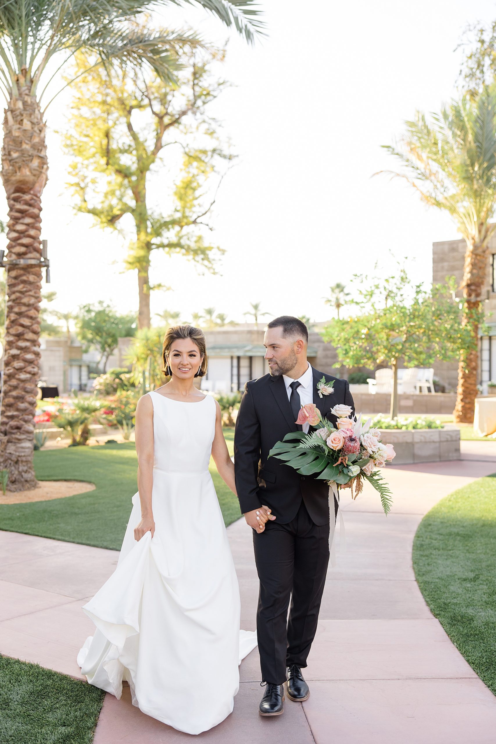 bride and groom walk together during wedding portraits at the Arizona Biltmore