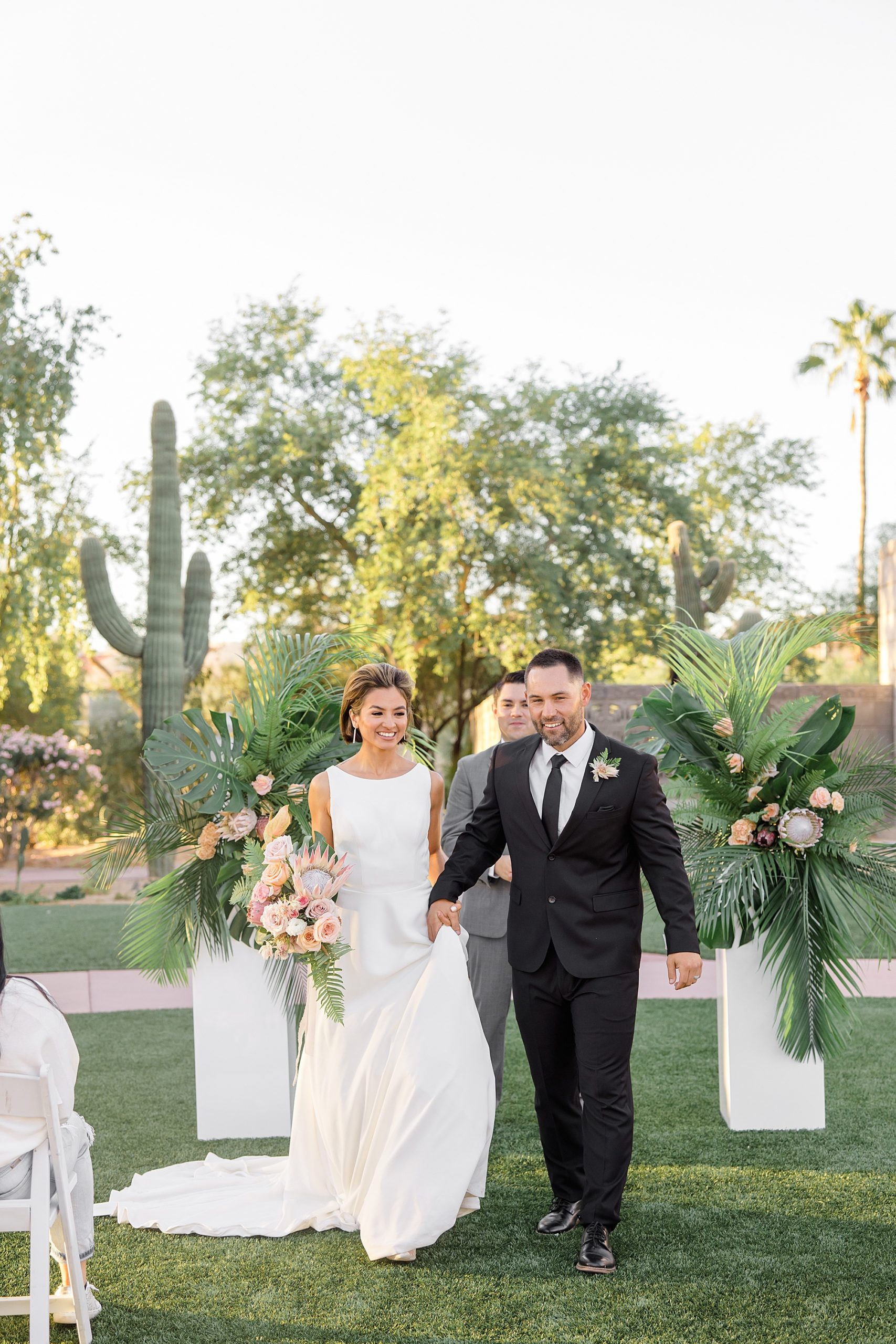 newlyweds walk up aisle after ceremony at the Arizona Biltmore