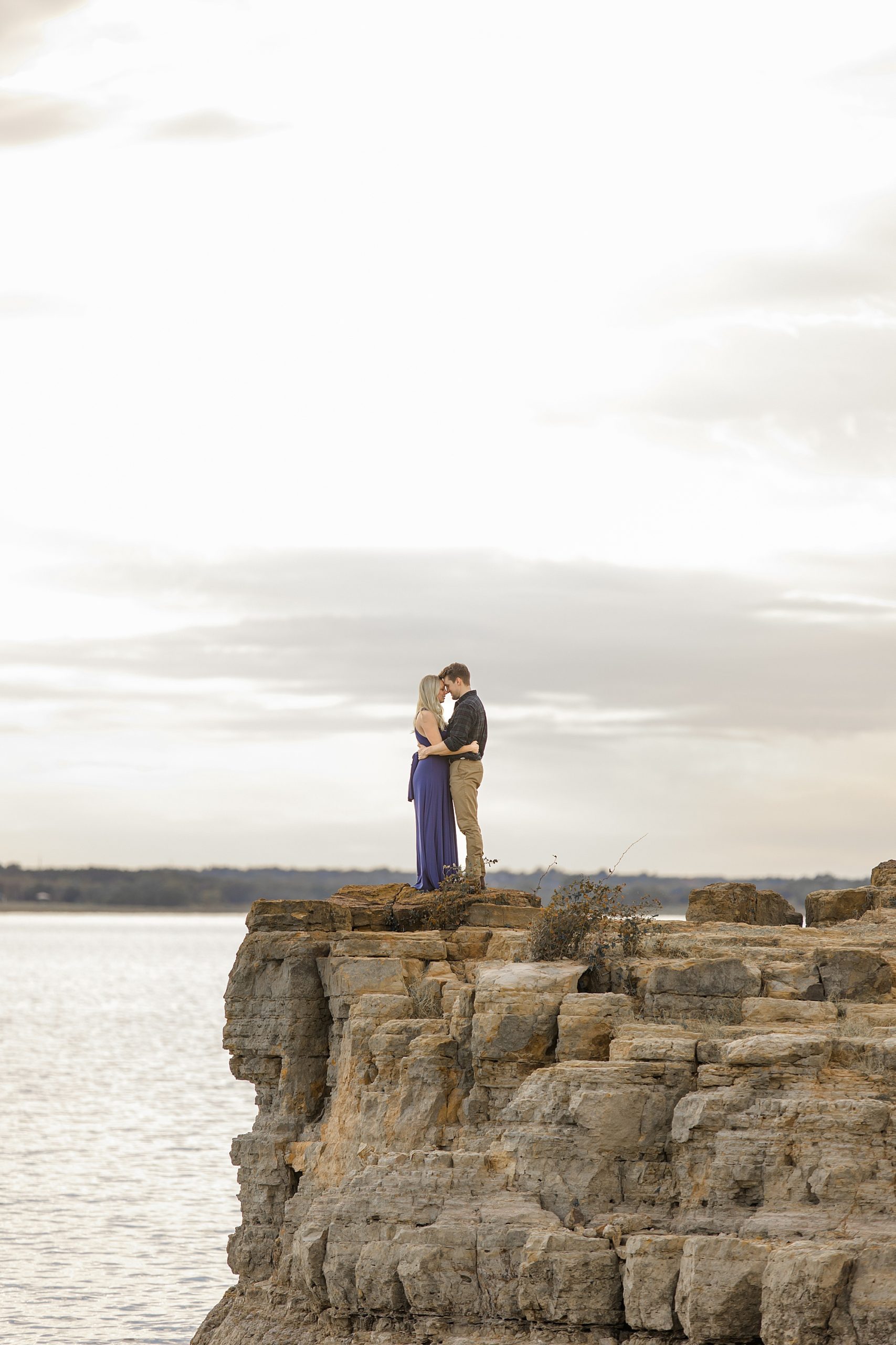 engaged couple stands on edge of rocks in Grapevine TX