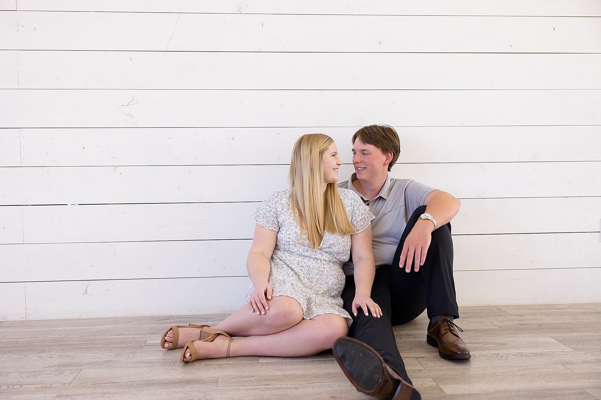 couple leans against white wall at The Nest at Ruth Farms