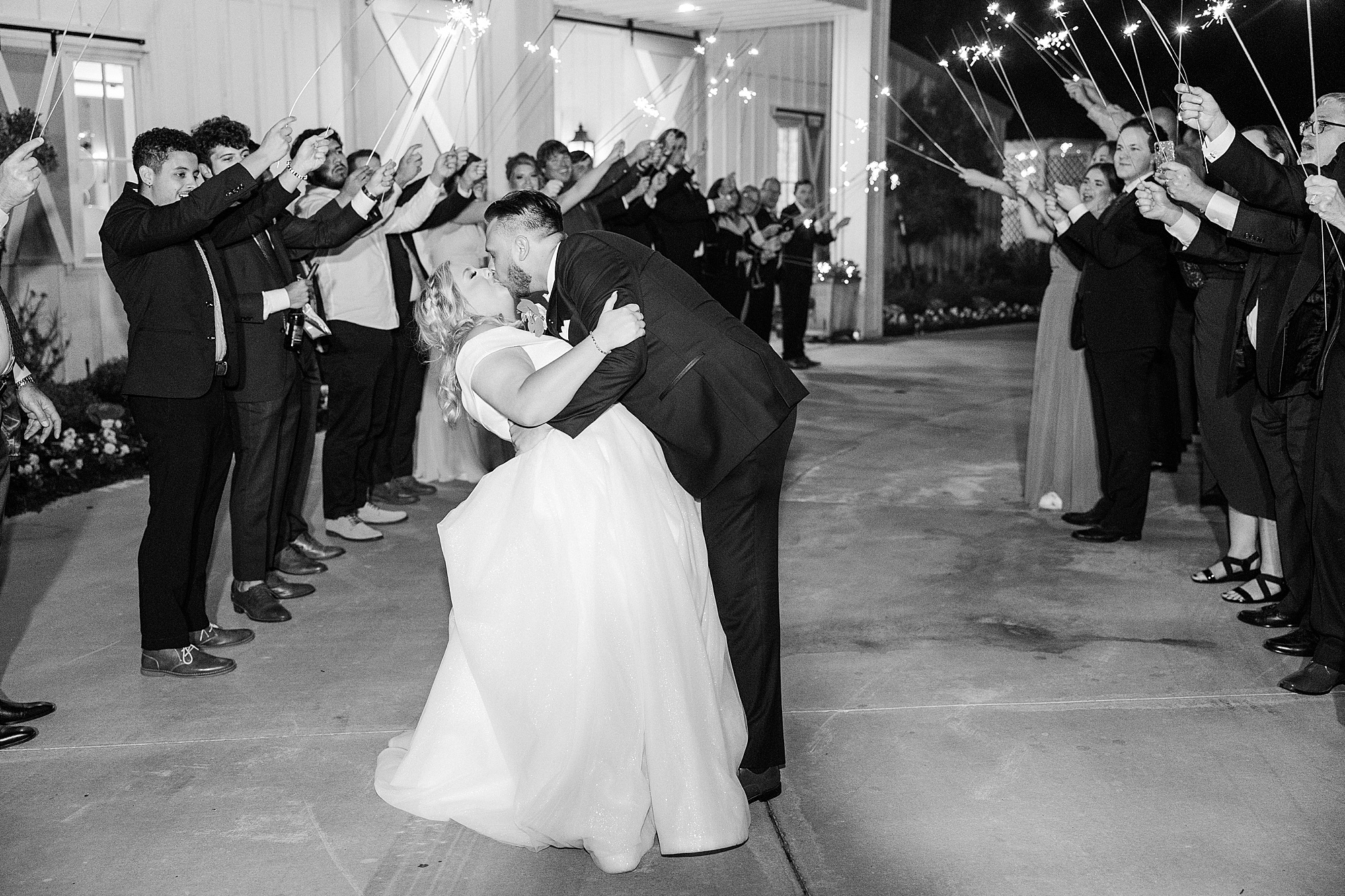 newlyweds kiss during sparkler exit at Ponder TX wedding reception